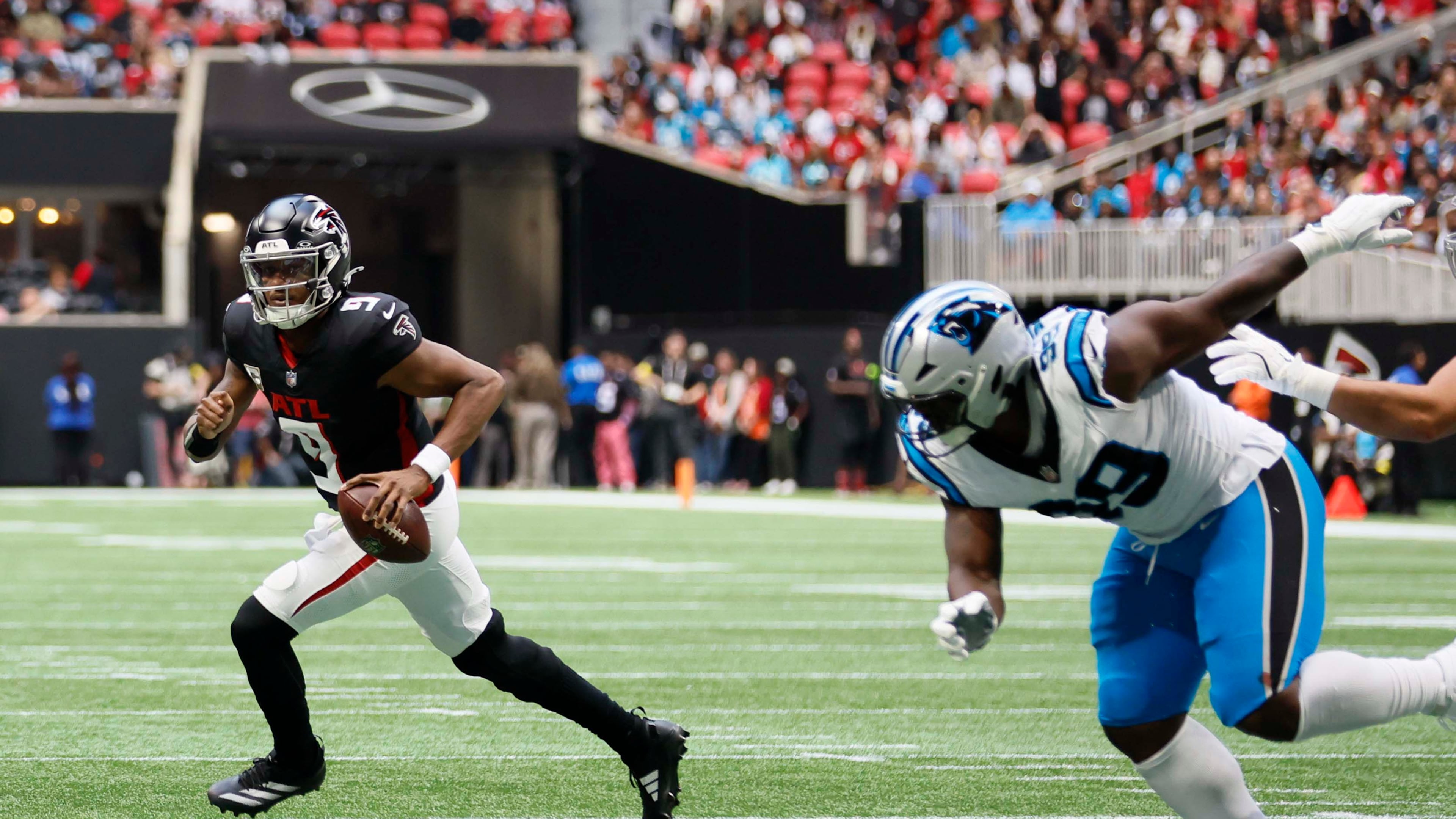 Falcons quarterback Michael Penix Jr. (left) escapes the pocket during the first half against the Panthers on Sunday, Nov. 16, 2025, at Mercedes-Benz Stadium in Atlanta. Penix injured his knee later in the game and had season-ending surgery Nov. 25. (Miguel Martinez/AJC)