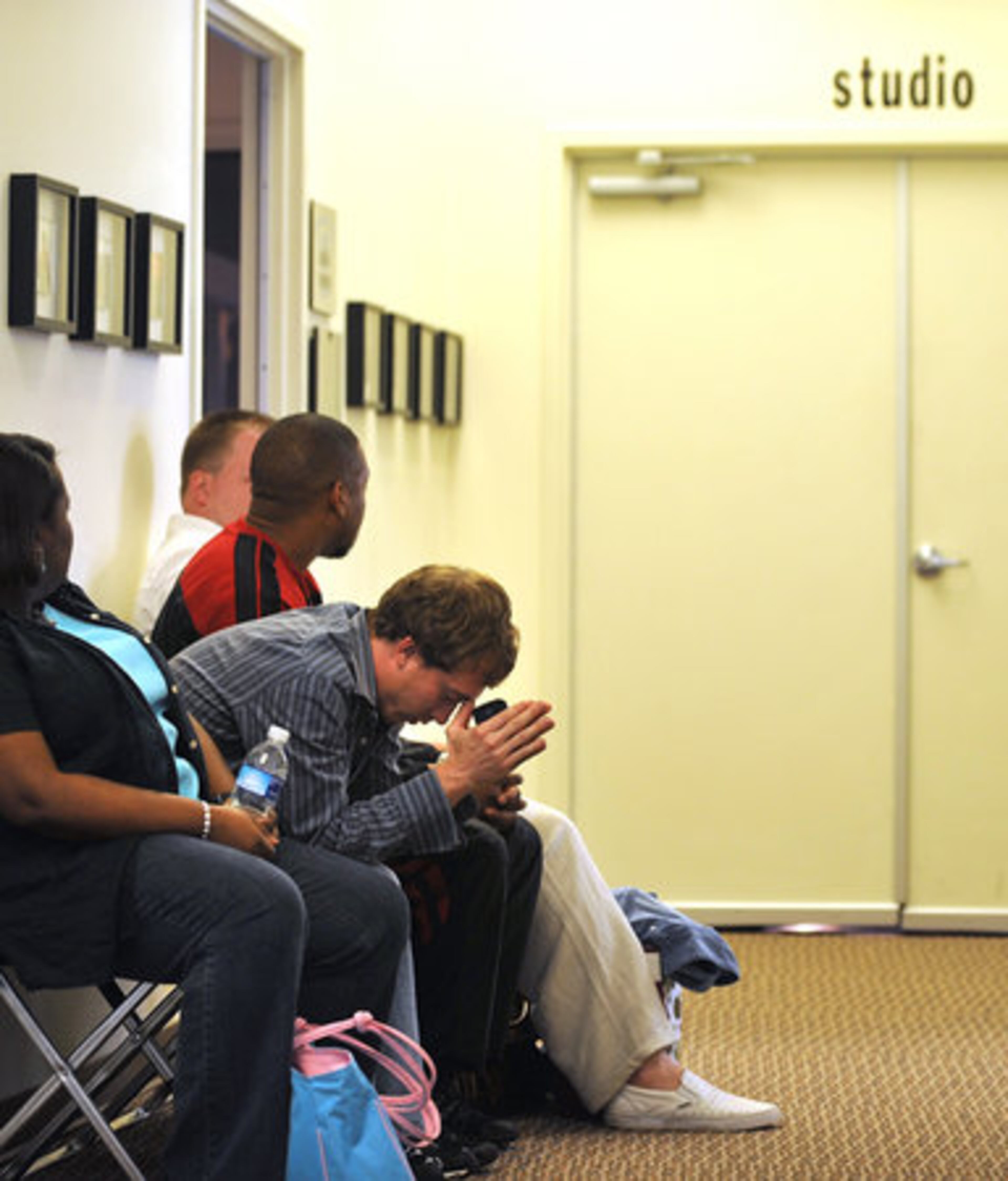Tommy Burns, 23, from Conyers prays as he waits his turn to enter the studio.