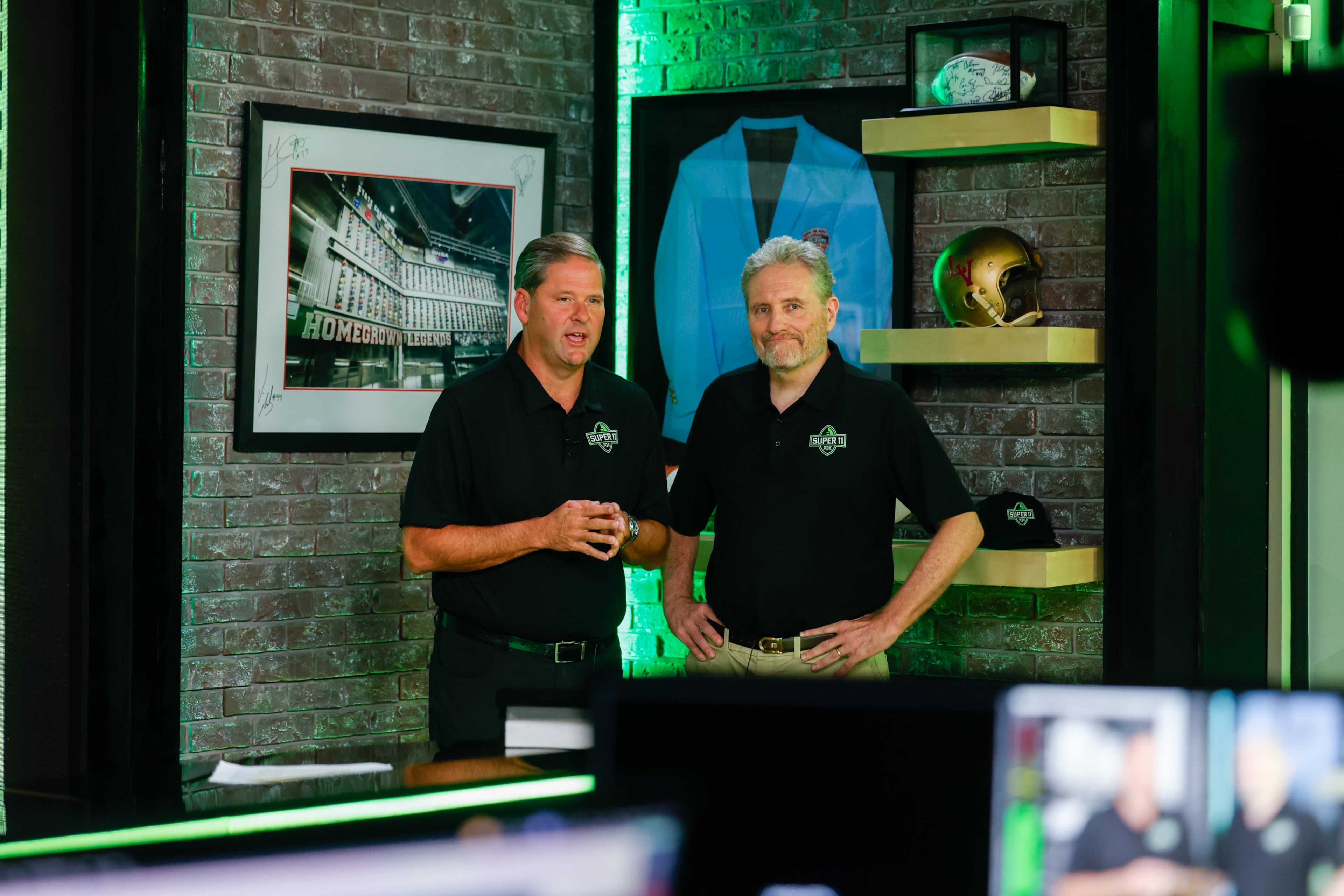 DawgNation’s Brandon Adams and AJC’s Todd Holcomb appear during the taping of the Super 11 reveal show at Score ATL in Roswell on Aug. 3, 2026. (Arvin Temkar/AJC)