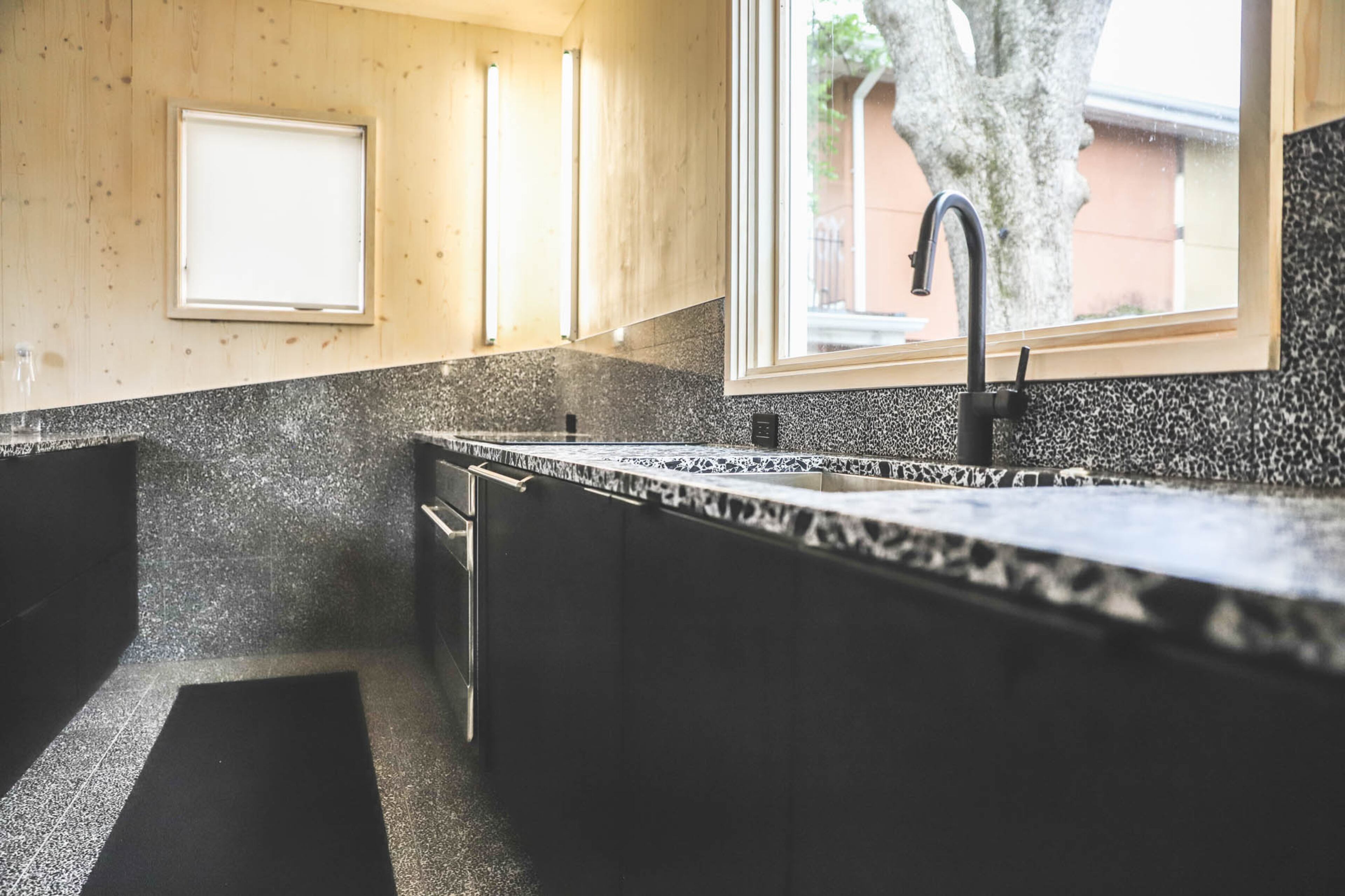 Terrazzo tile by Eco-Terr also serves as a backsplash before meeting up with cross-laminated timber. The terrazzo is applied as a thin tile instead of being poured in place and polished.