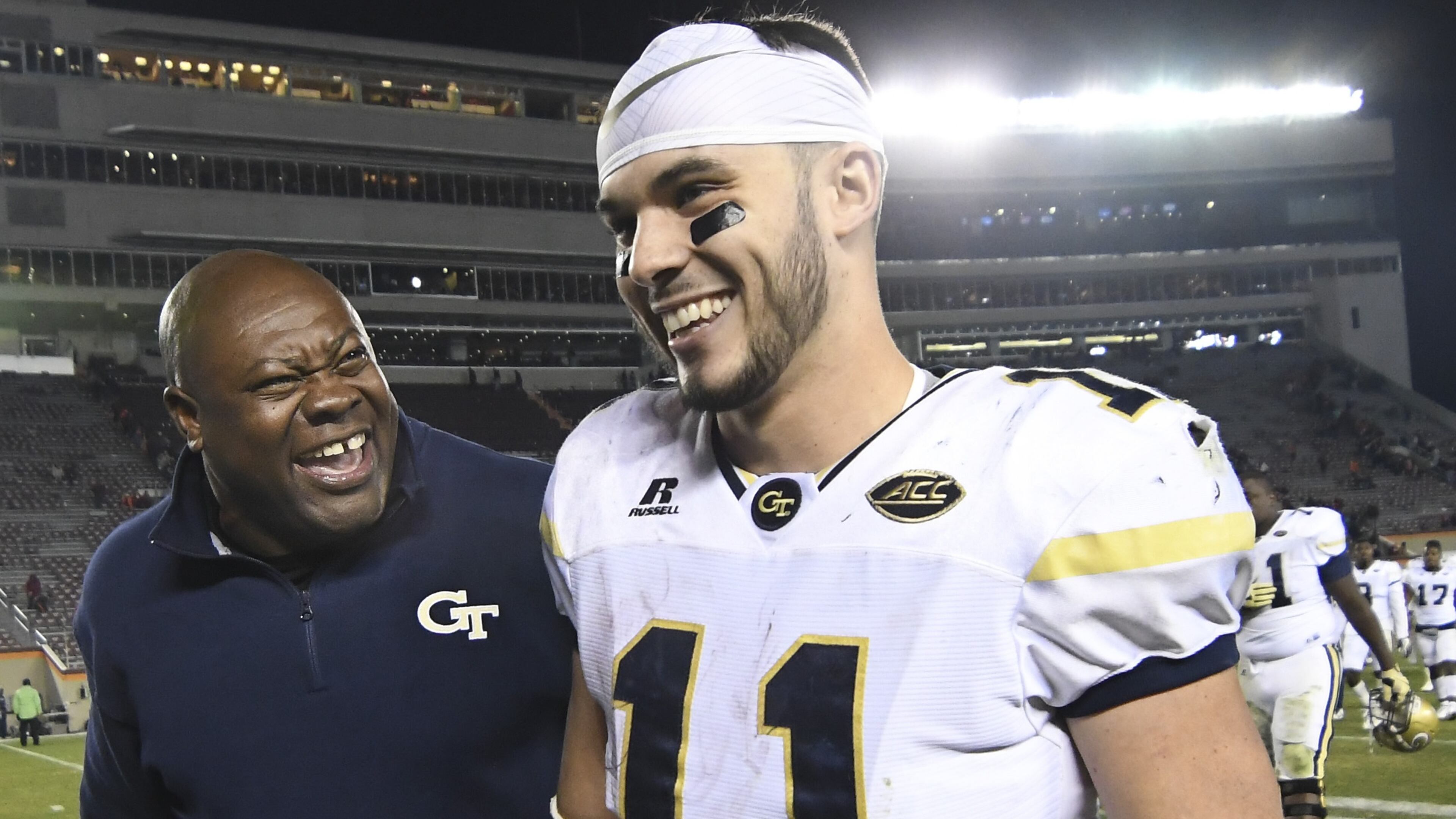 Georgia Tech quarterback Matthew Jordan walks off the Lane Stadium field with team chaplain Derrick Moore after leading the Yellow Jackets to an upset win over the Hokies last November in Blacksburg, Va. (GETTY IMAGES)