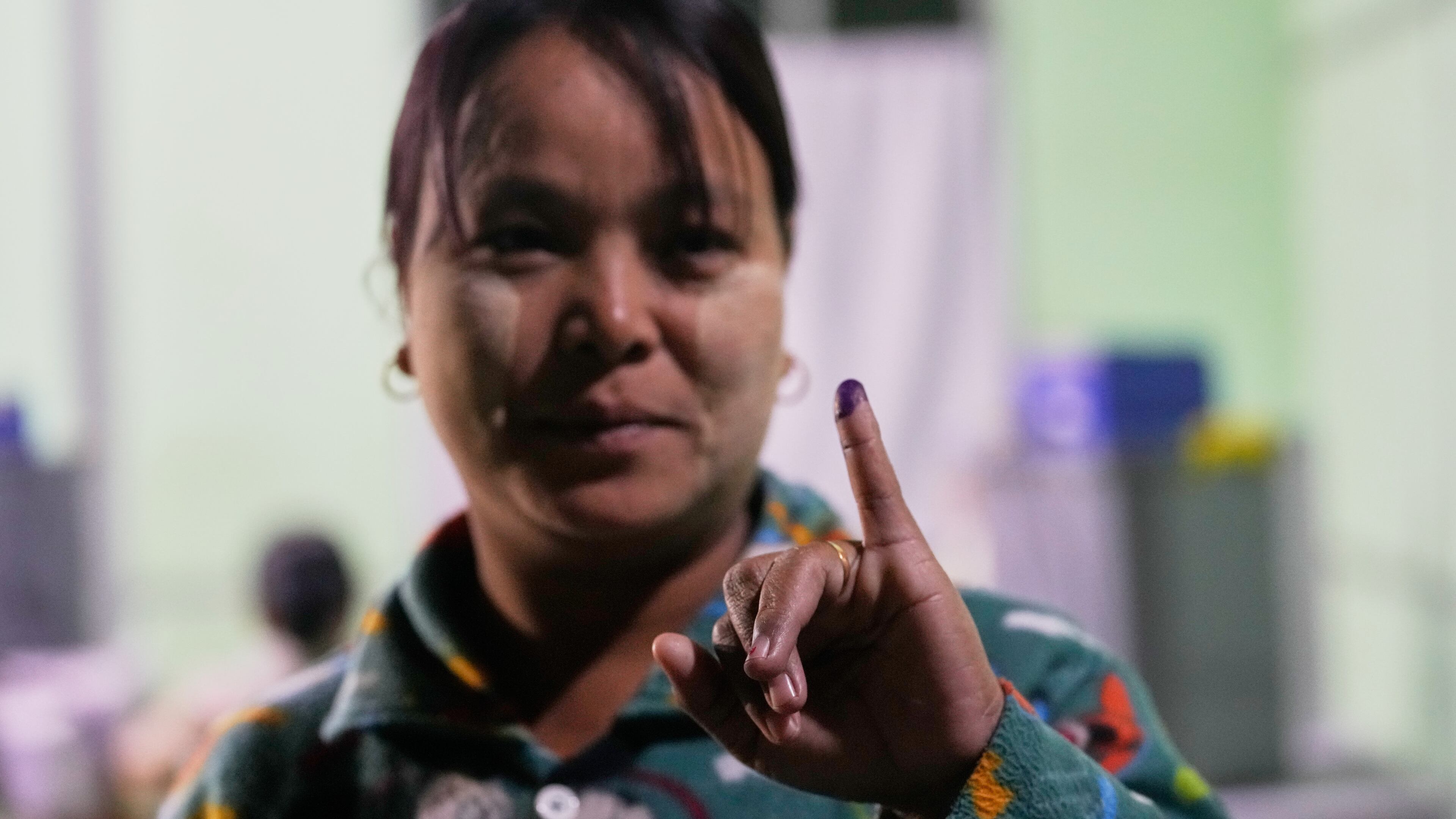 A voter holds up her finger marked with ink indicating she voted at a polling station during the third phase of general election in Mandalay, central Myanmar, Sunday, Jan. 25, 2026. (AP Photo/Aung Shine Oo)