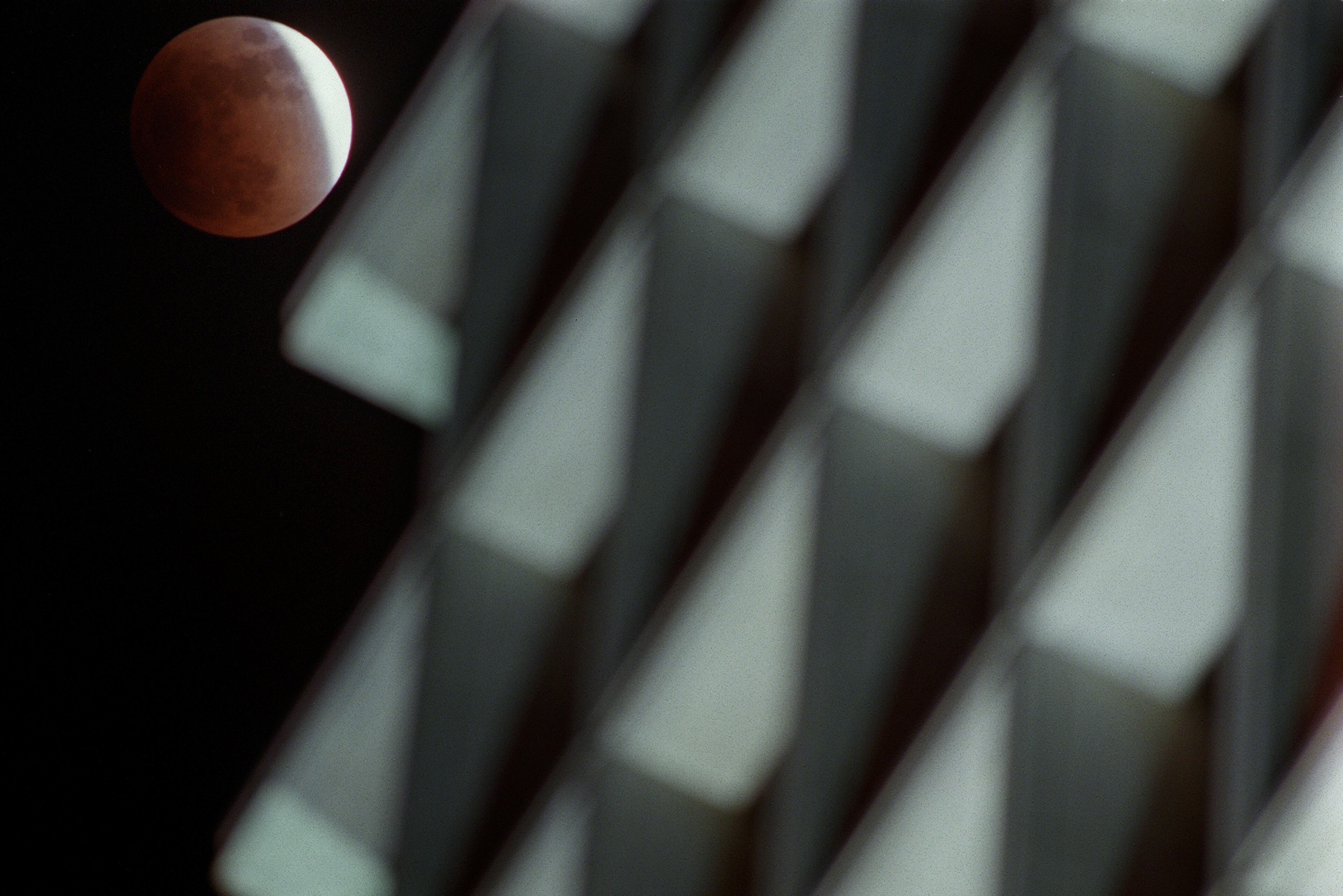 000120-ATLANTA-The moon disapears behind the earth's shadow Thursday evening beside the SouthTrust Bank building in Midtown Atlanta. The total lunar eclipse was the first visible from Atlanta since 1996. (BEN GRAY/STAFF)
