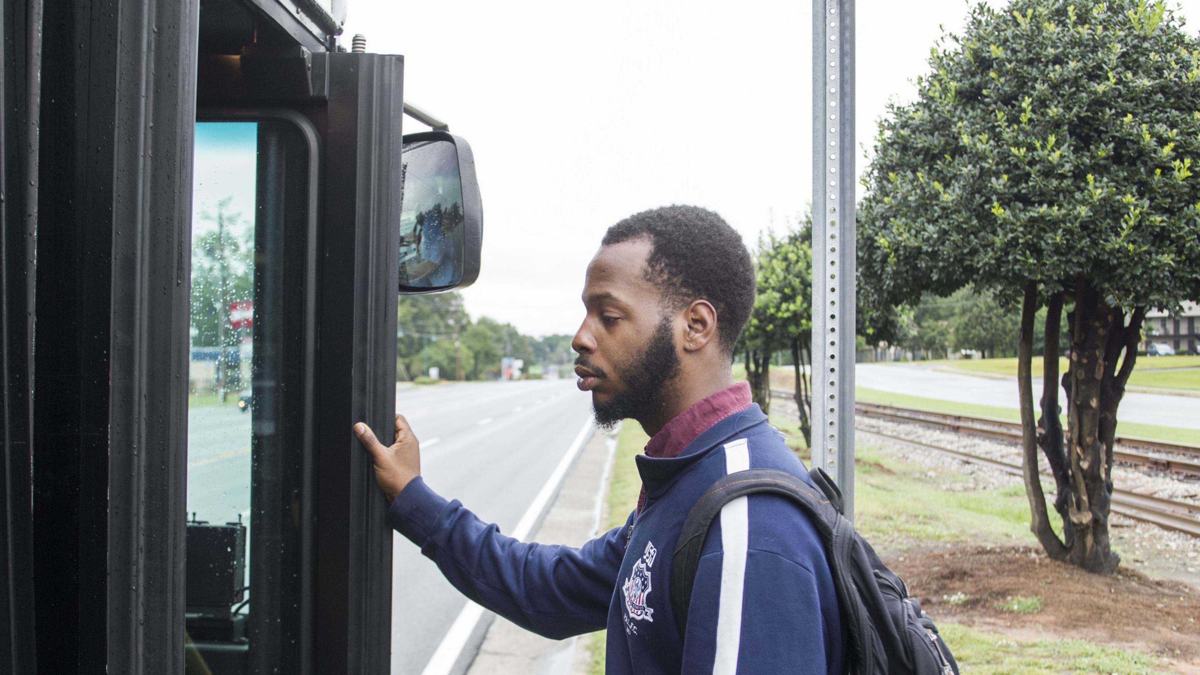 After after a 20-minute walk, and waiting an additional 10 minutes in the rain, DeAngelo Bowie, 24, catches the bus to get to work. Bowie, 24, dropped out of Georgia State University in 2013 after a series of family health crises and financial problems derailed his dream of being a history teacher. Chad Rhym/ Chad.Rhym@ajc.com