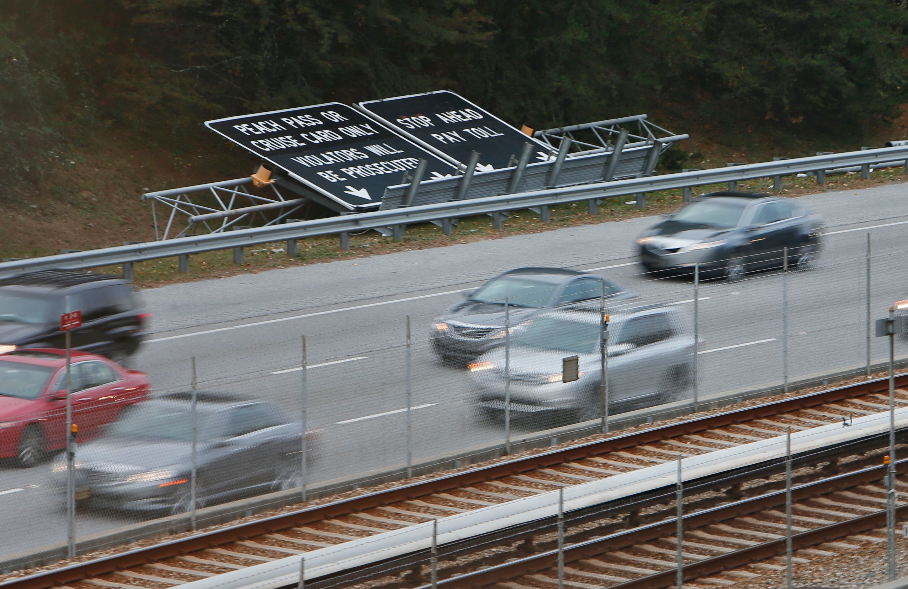 The toll booth signs have been taken down, and soon the toll booths will be gone. Morning commute traffic on GA 400 in the toll booth area. GA 400 tolls will end Nov. 22. BOB ANDRES / BANDRES@AJC.COM
