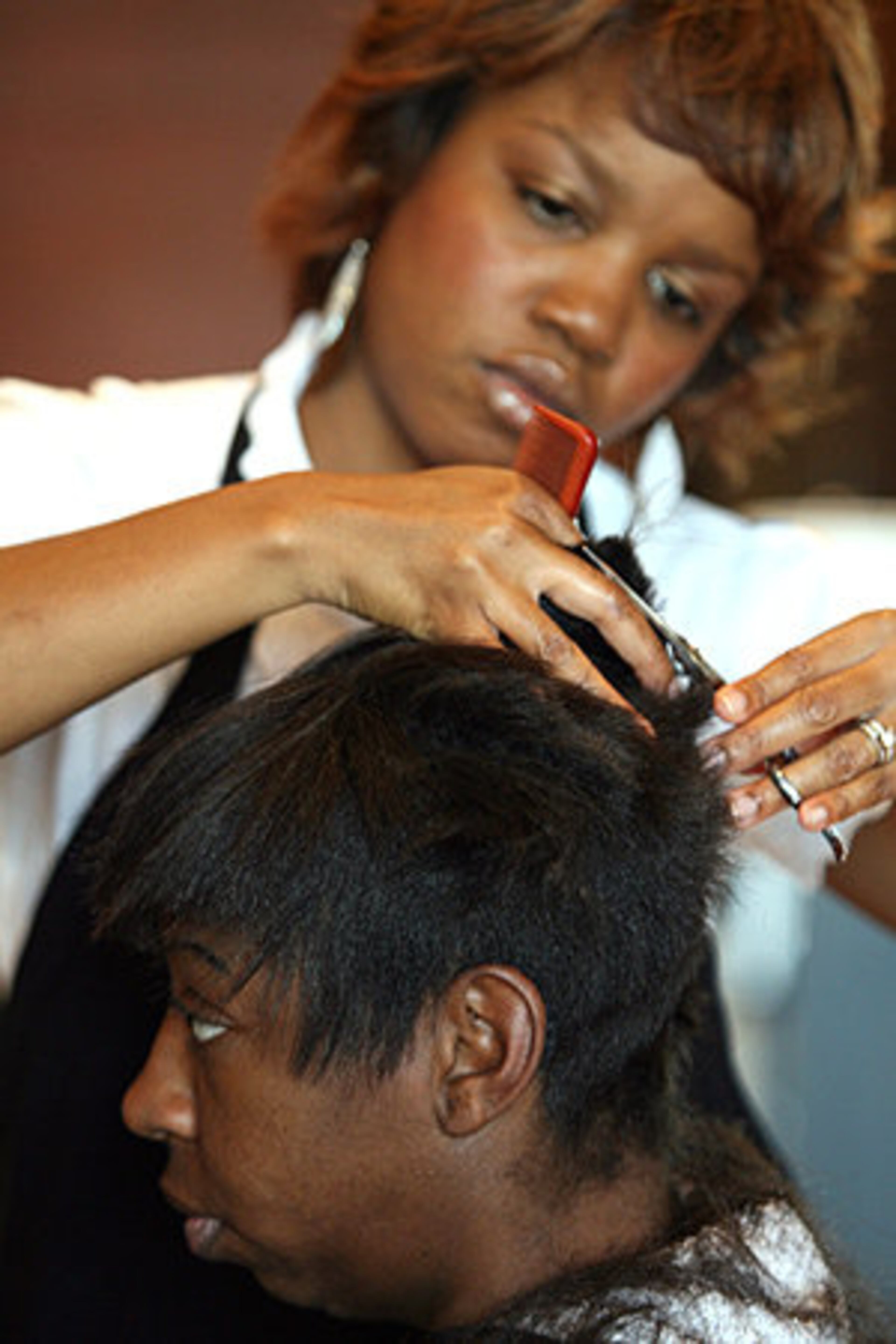 Latricia Johnson gets her hair cut by stylist Carlisa "CJ" Neal.