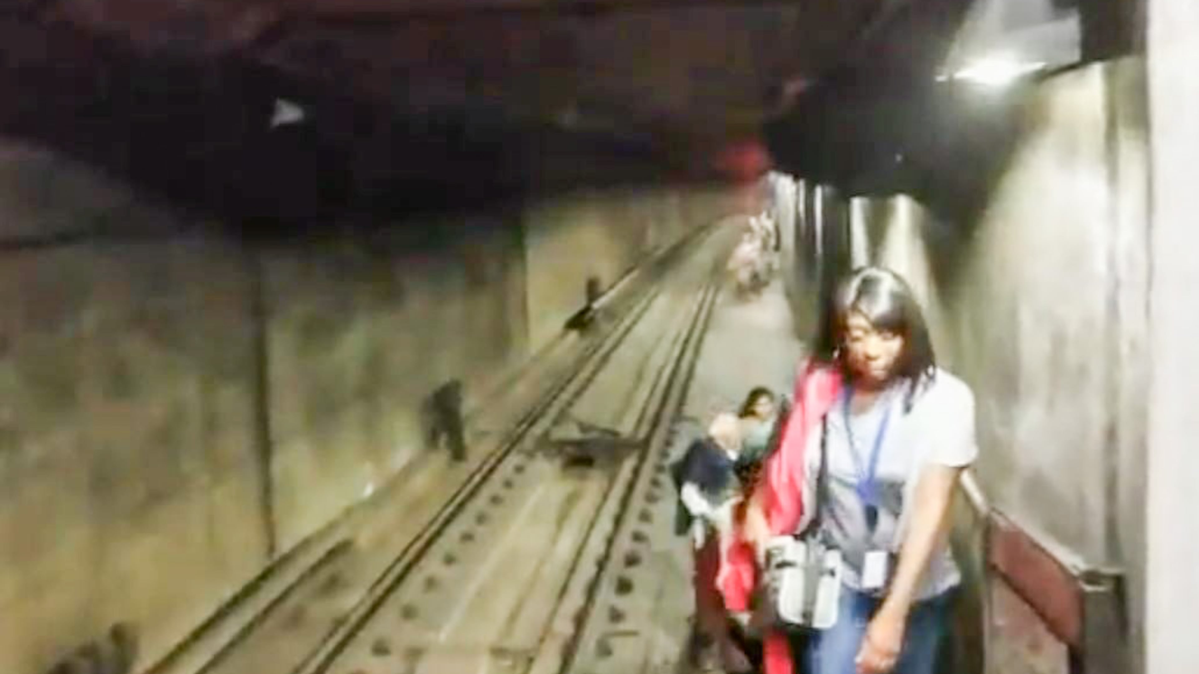 MARTA passengers walk through a tunnel after climbing out of a stalled train car near the Arts Center station on Wednesday night.