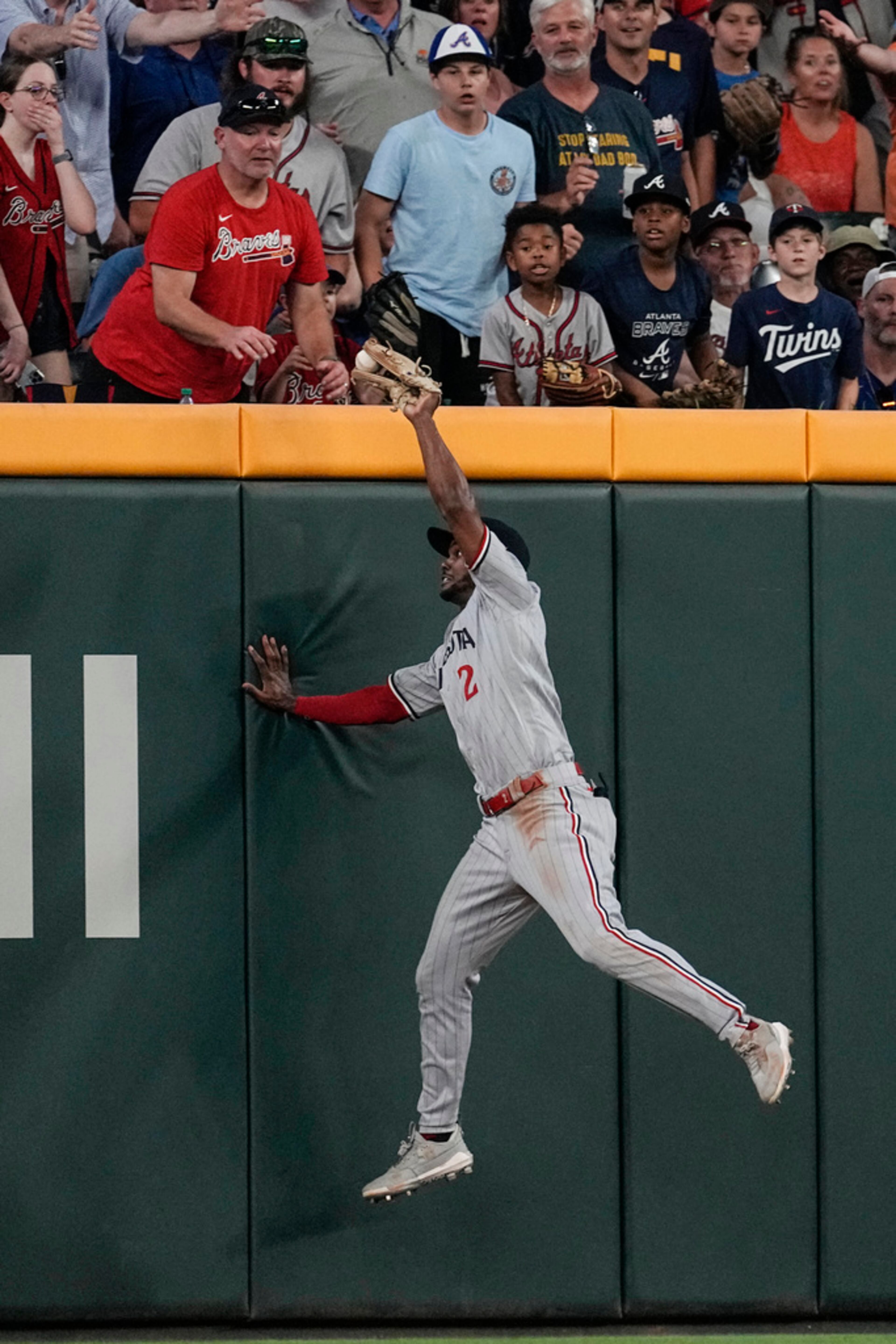 Minnesota Twins center fielder Michael A. Taylor catches a fly ball by Atlanta Braves' Matt Olson at the wall during the seventh inning of a baseball game Tuesday, June 27, 2023, in Atlanta. (AP Photo/John Bazemore)