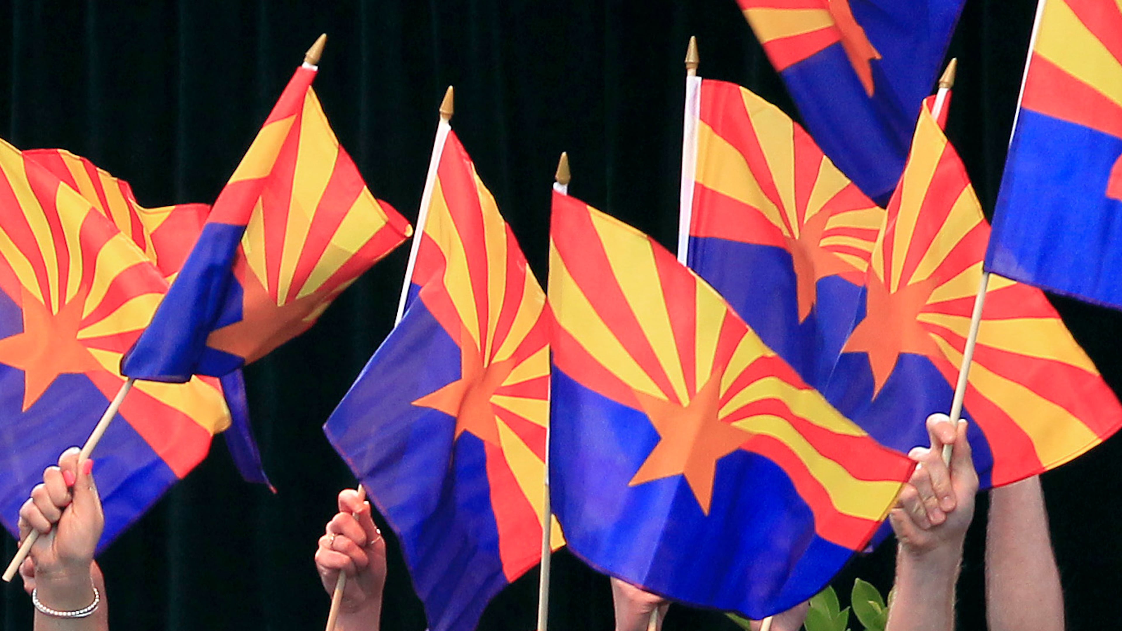 FILE - Members of the Arizona State University Barrett Choir wave Arizona state flags during the celebration of the 100th anniversary of Arizona's statehood, Feb. 14, 2012, in Phoenix.(AP Photo/Ross D. Franklin, File)