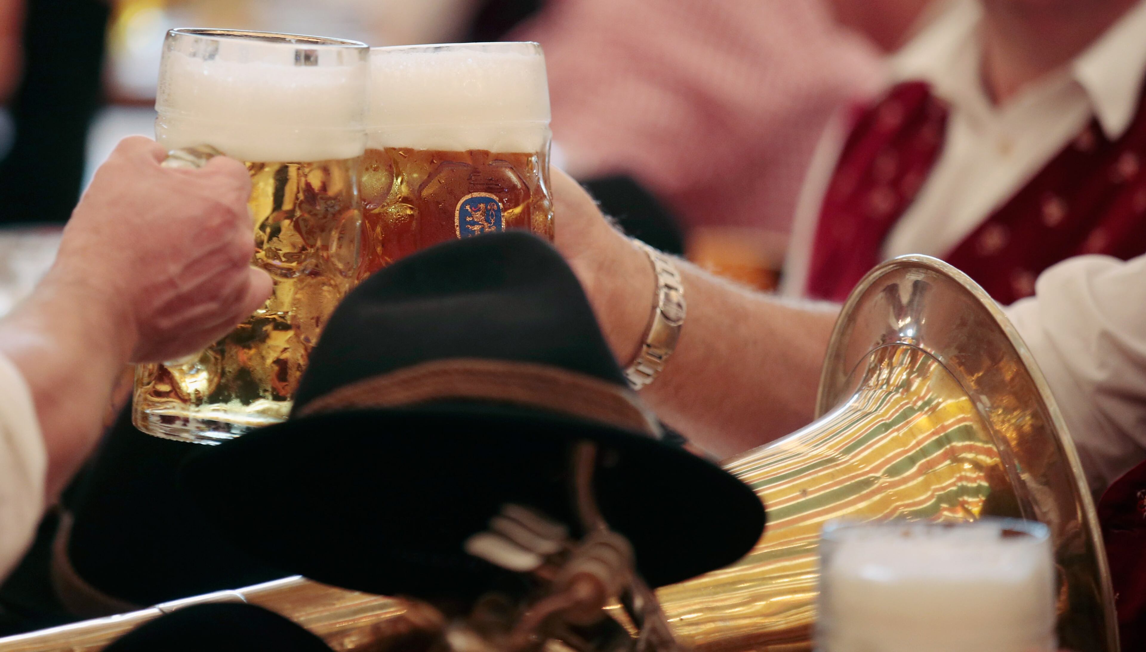 MUNICH, GERMANY - SEPTEMBER 21: Participants of the Parade of Costumes and Riflemen (Trachten- und Schuetzenzug) enjoy drinking beer at Schuetzen beer tent on the second day of the 2014 Oktoberfest on September 21, 2014 in Munich, Germany. The 181st Oktoberfest will be open to the public from September 20 through October 5 and traditionally draws millions of visitors from across the globe in the world's largest beer fest. (Photo by Johannes Simon/Getty Images)