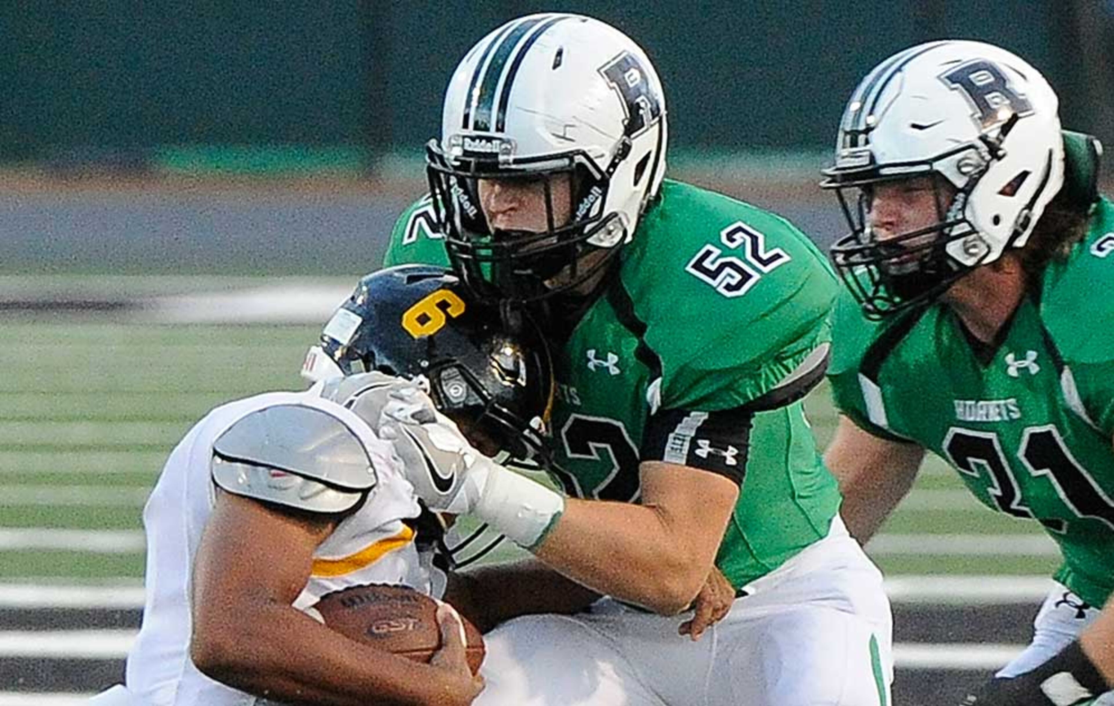 Roswell LB Mitch Stone (52) tackles Central Gwinnett QB Hunter Sims with backup from LB Sam Diroberto (31) during Friday's game.