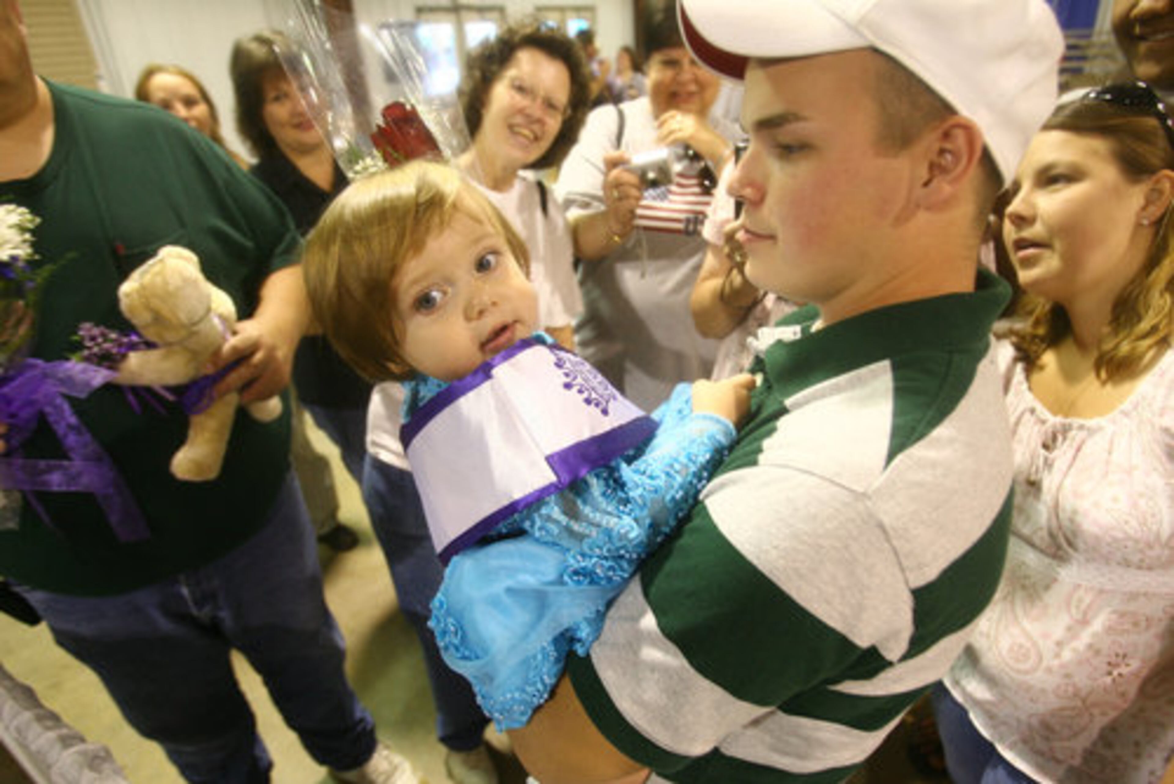 2008 Baby Miss Gwinnett Madilyn Moon is held by her uncle Daniel Geyer of Lawrenceville as she is surrounded by family and friends after winning the title.