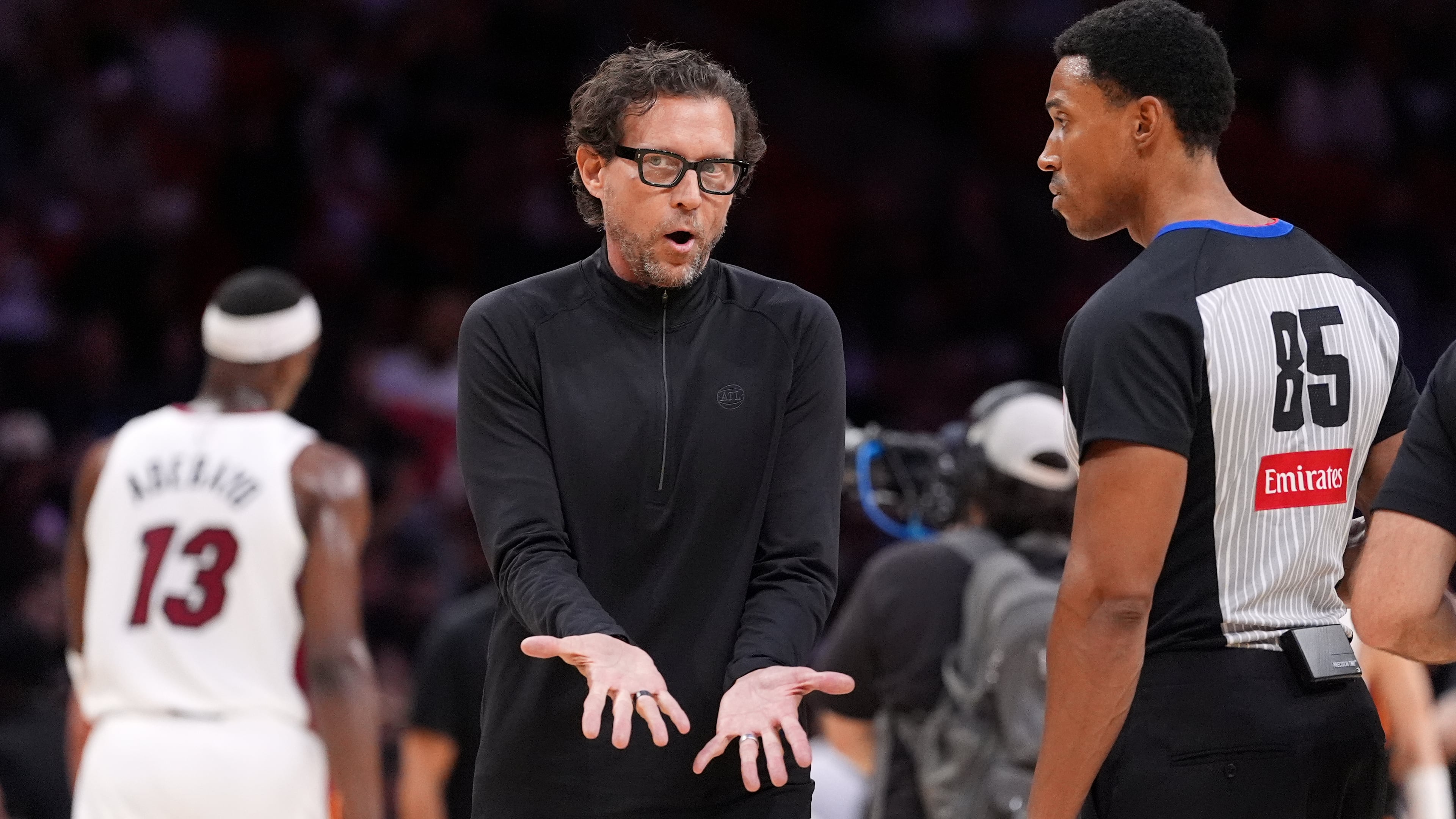 Atlanta Hawks head coach Quin Snyder, center, talks with referee Robert Hussey during the first half of an NBA basketball game against the Miami Heat, Sunday, April 12, 2026, in Miami. (Rebecca Blackwell/AP)