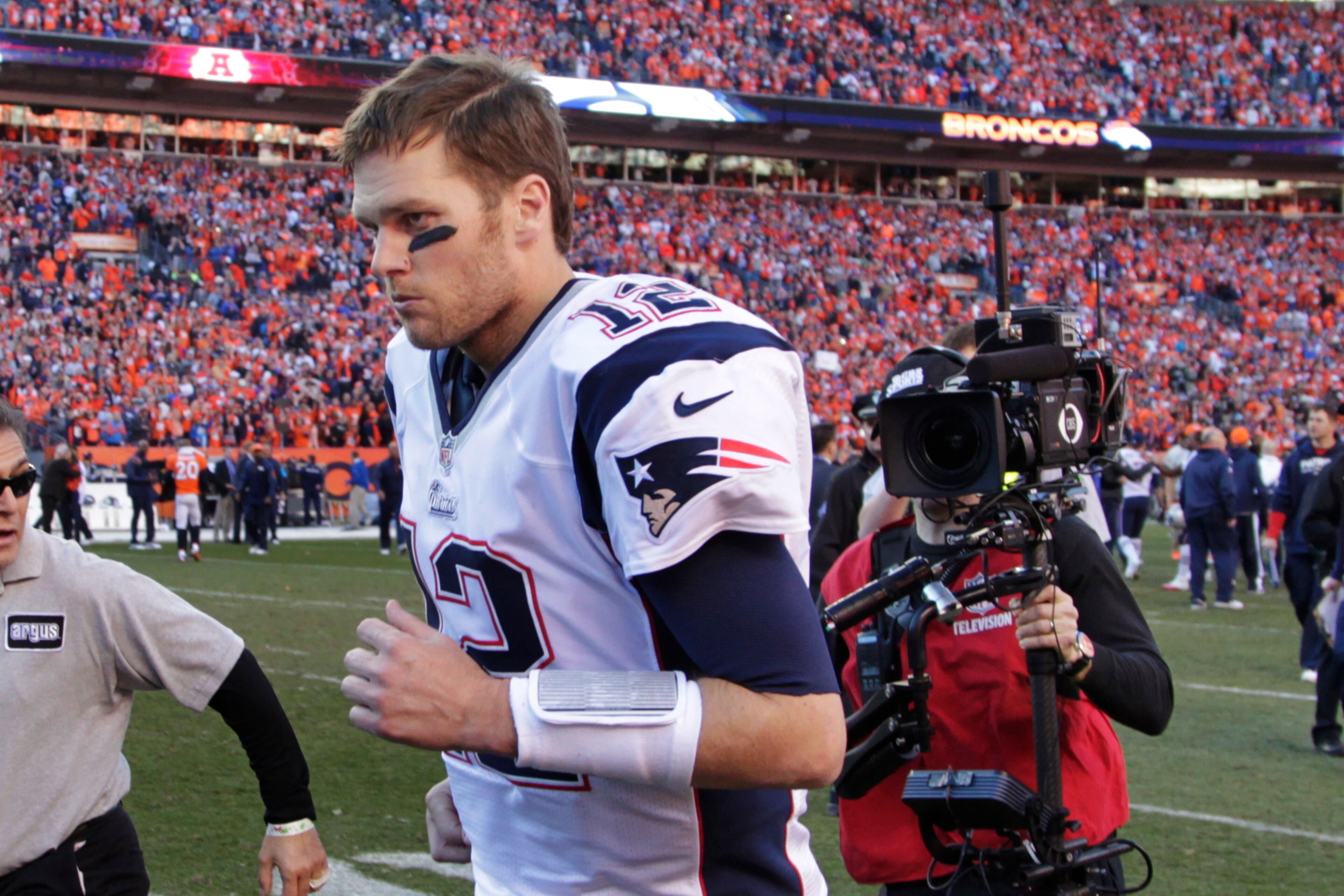 New England Patriots quarterback Tom Brady runs off the field after the AFC Championship NFL playoff football game in Denver, Sunday, Jan. 19, 2014. The Broncos defeated the Patriots 26-16 to advance to the Super Bowl. (AP Photo/Joe Mahoney)