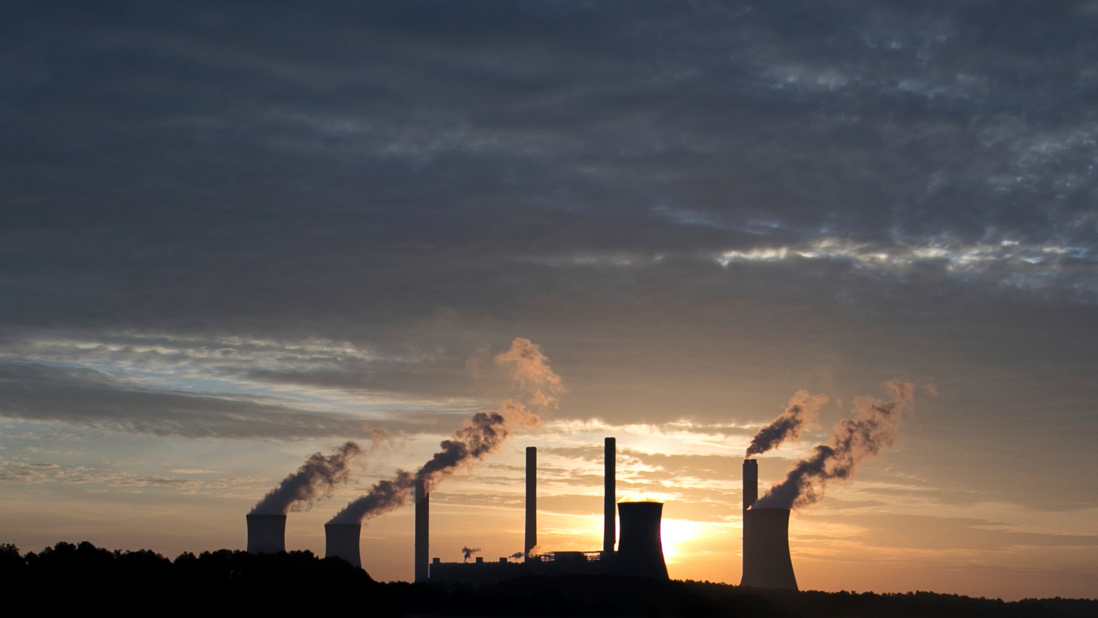 In this June 3, 2017, file photo, the coal-fired Plant Scherer, one of the nation's top carbon dioxide emitters, stands in the distance in Juliette, Ga. A new poll finds that less than a third of Americans support President Donald Trumps decision to withdraw from the Paris climate accord, with just 18 percent of respondents agreeing with his claim that pulling out of the international agreement to reduce carbon emissions will help the U.S. economy.(AP Photo/Branden Camp, File)