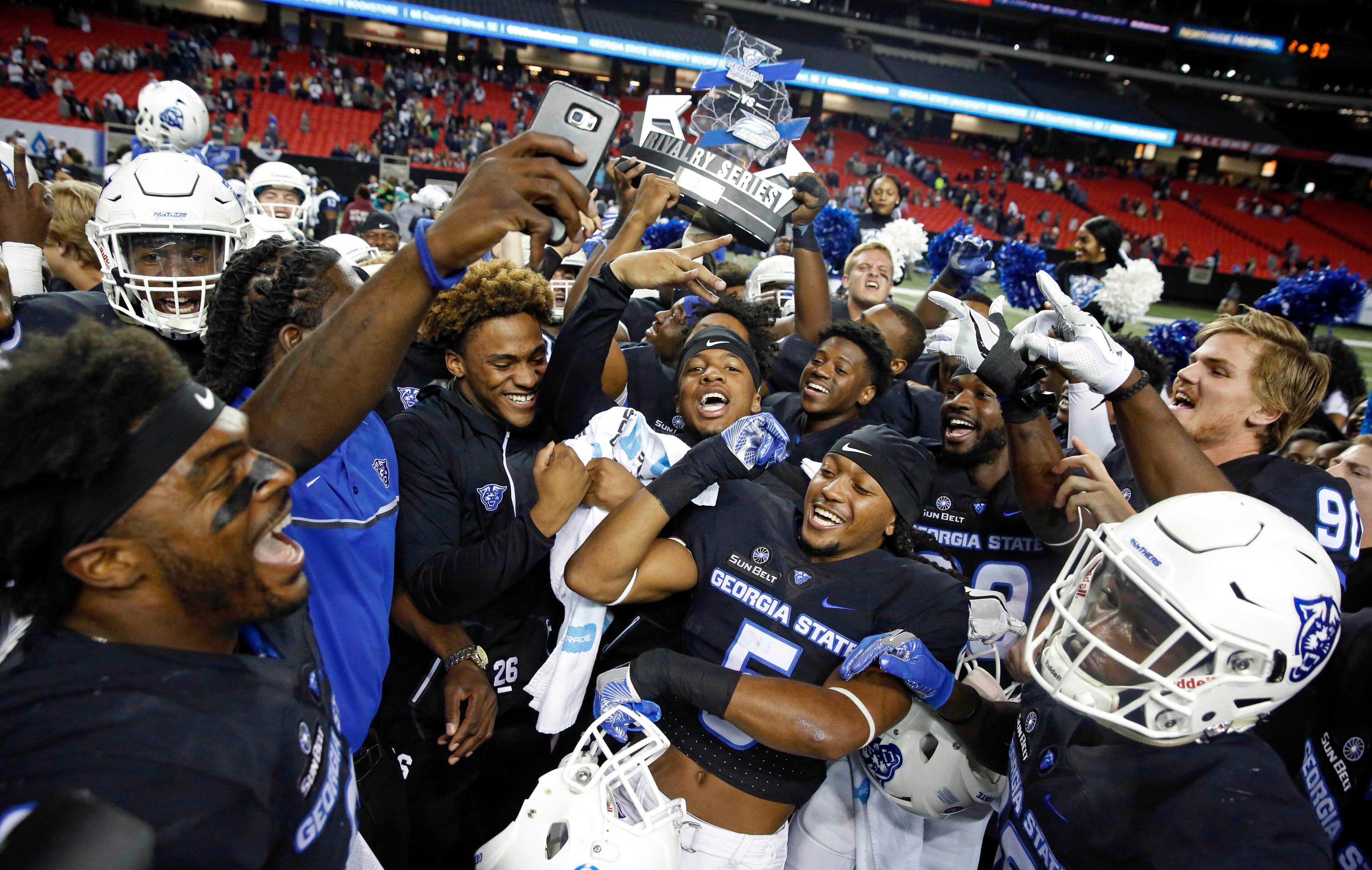 November 19, 2016 - Atlanta, Ga: Georgia State Panthers players celebrate with the Rivalry Series trophy after their win against the Georgia Southern Eagles at the Georgia Dome Saturday November 19, 2016, in Atlanta, Ga. Georgia State won 30-24. PHOTO / JASON GETZ