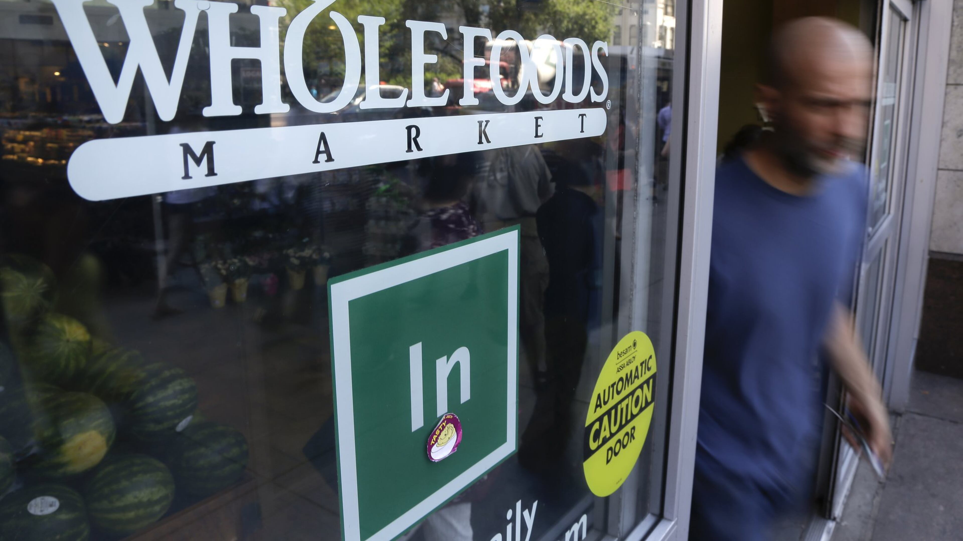 A shopper leaves a Whole Foods Market store in Union Square in New York City on June 24. Whole Foods has agreed to pay $500,000 to settle overpricing allegations made by the New York City Department of Consumer Affairs.