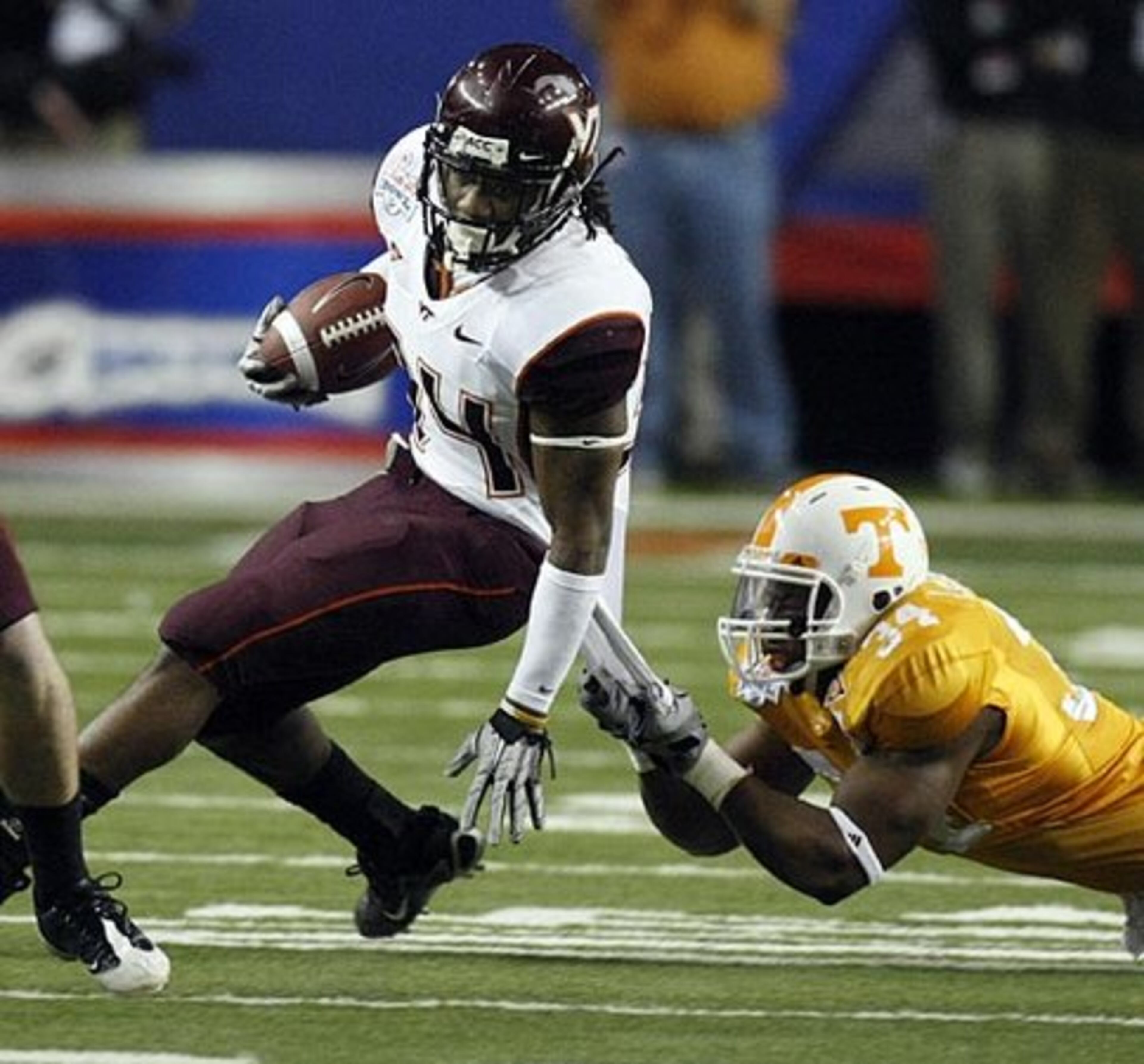 Virginia Tech tailback Ryan Williams (34) is caught with a shirt tail tackle by Tennessee linebacker Herman Lathers (34).