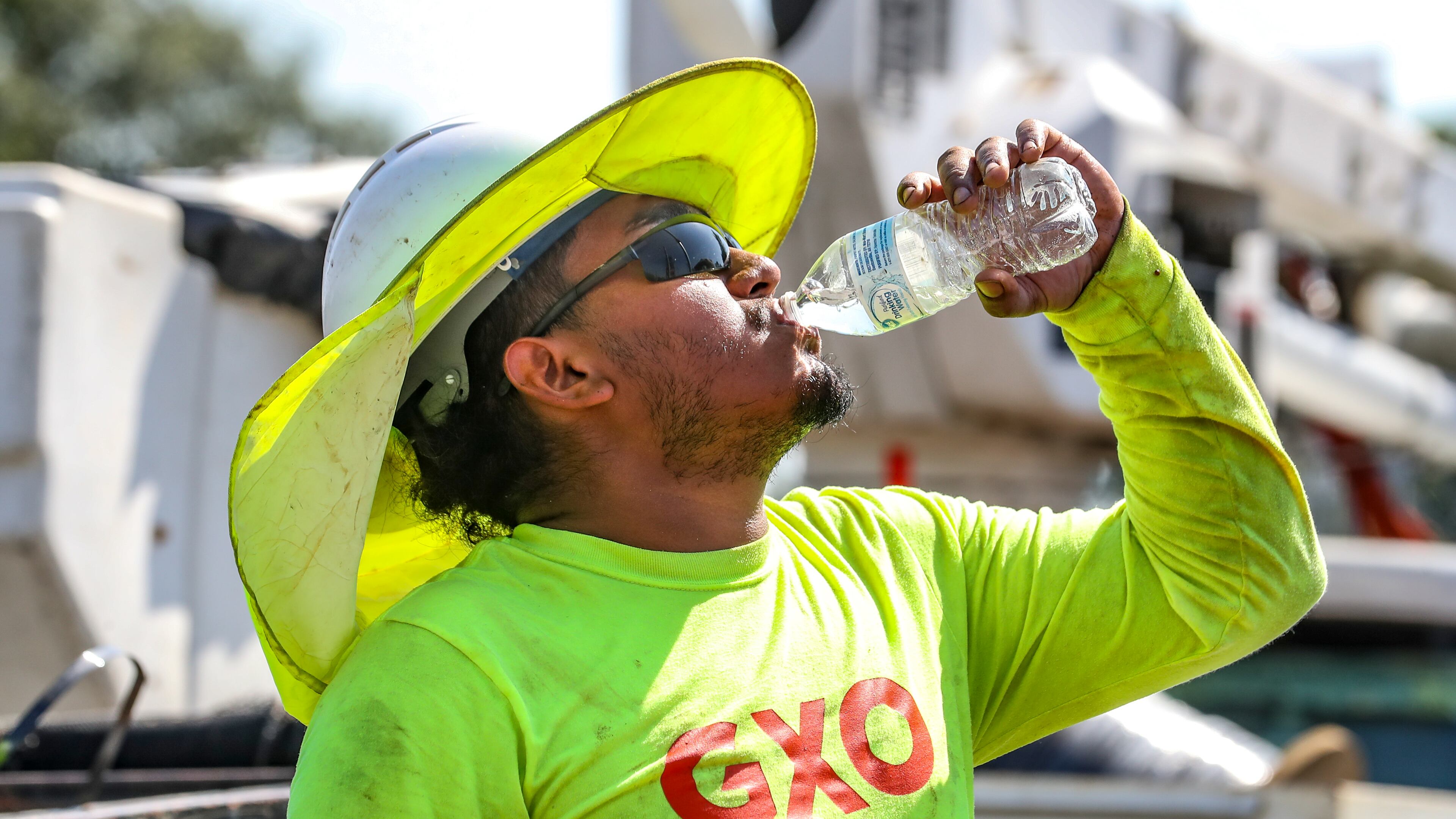 Fernando Rosales with RJH Electrical Contractors worked on installing an electrical box on Northside Drive near I-75 gets hydrated during the oppressive heat in metro Atlanta on Monday, Aug. 14, 2023. (John Spink / John.Spink@ajc.com)
