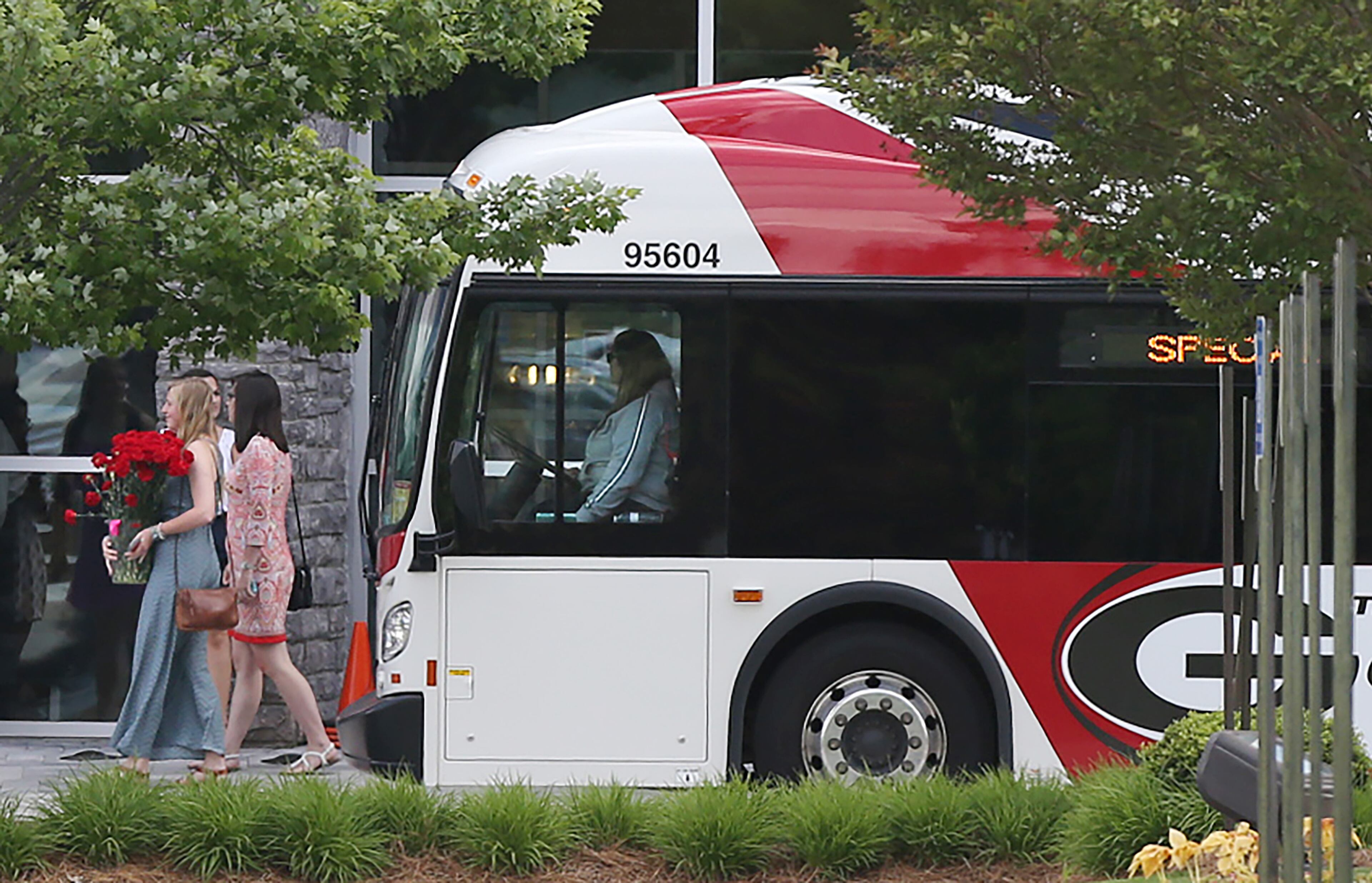 Girls carry red flowers arrived on a bus from the University of Georgia for a joint funeral service for Kayla Canedo and Brittany Feldman at North Point Community Church in Alpharetta on Tuesday, May 3, 2016, in Alpharetta. It is the third funeral for the four UGA crash victims. The two were best friends since they were toddlers making their joint funeral somewhat fitting. Curtis Compton / ccompton@ajc.com