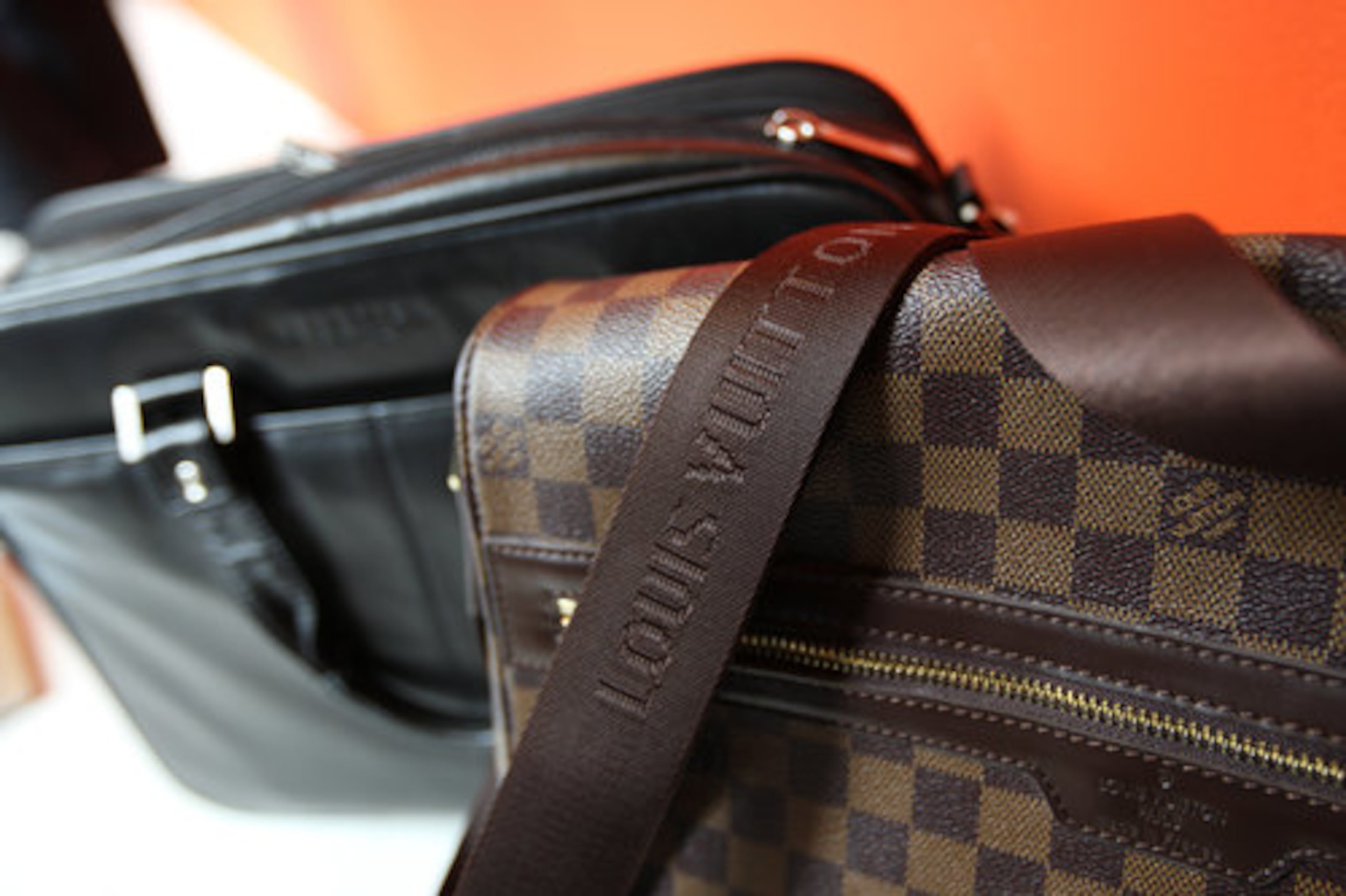 Epstein's accessories include a black Kenneth Cole messenger bag and a Louis Vuitton messenger bag.
