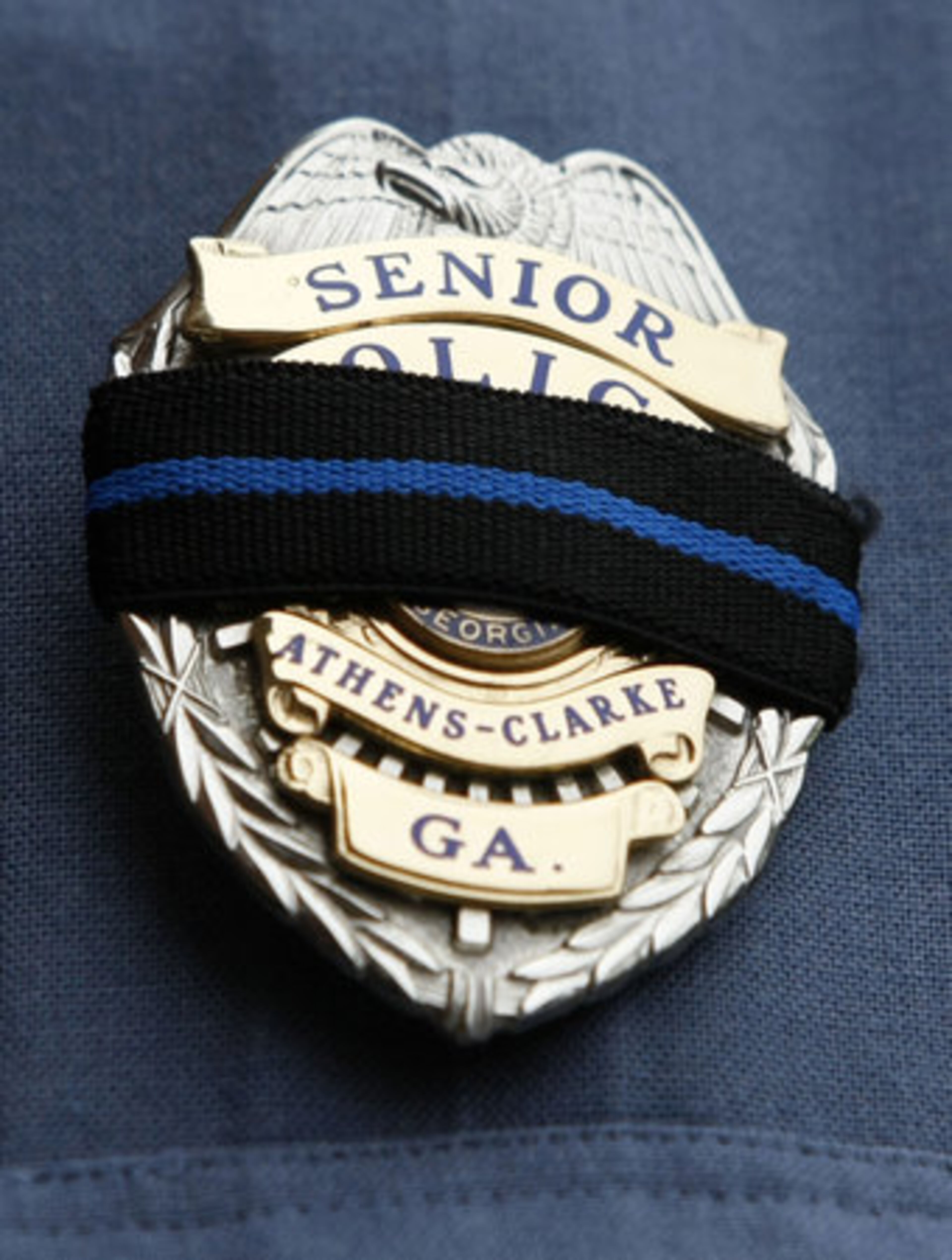 Athens-Clarke County Senior Officer Doug Wyatt wears black over his badge for the funeral of slain Athens Senior Police Officer Elmer " Buddy" Christian at the Classic Center Theatre in Athens on Sunday, March 27, 2011.