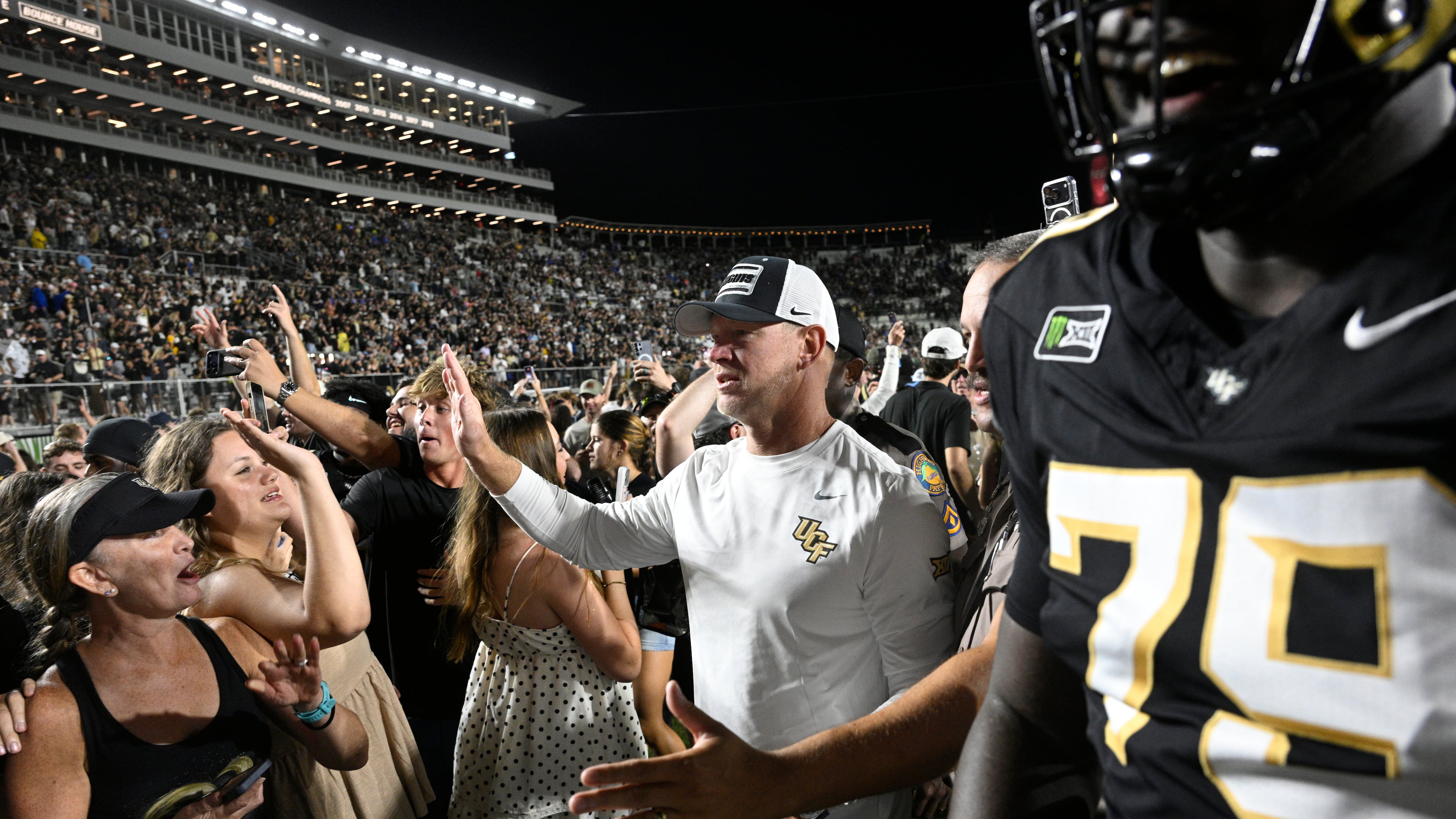 Central Florida head coach Scott Frost, center, leaves the field after a double-overtime win over BYU iin an NCAA college football game, Saturday, Oct. 24, 2026, in Orlando, Fla. (AP Photo/Phelan M. Ebenhack)