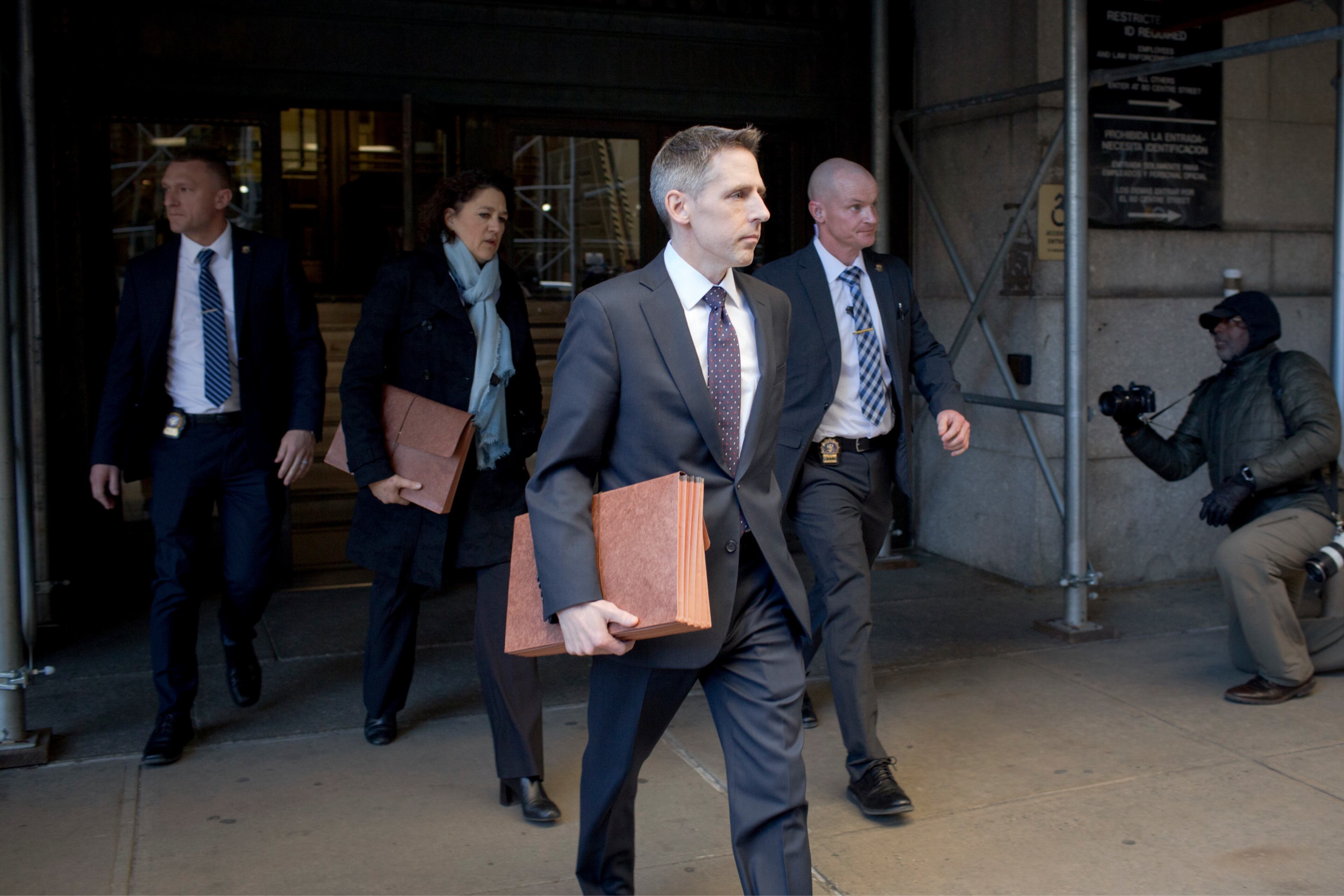 Matthew Colangelo, center, and Susan Hoffinger, rear, prosecutors with the Manhattan district attorney's office, walk between Manhattan Criminal Court buildings in Manhattan, March 30, 2023. A Manhattan grand jury voted to indict Donald J. Trump on Thursday for his role in paying hush money to a porn star, according to four people with knowledge of the matter. (Anna Watts/The New York Times)