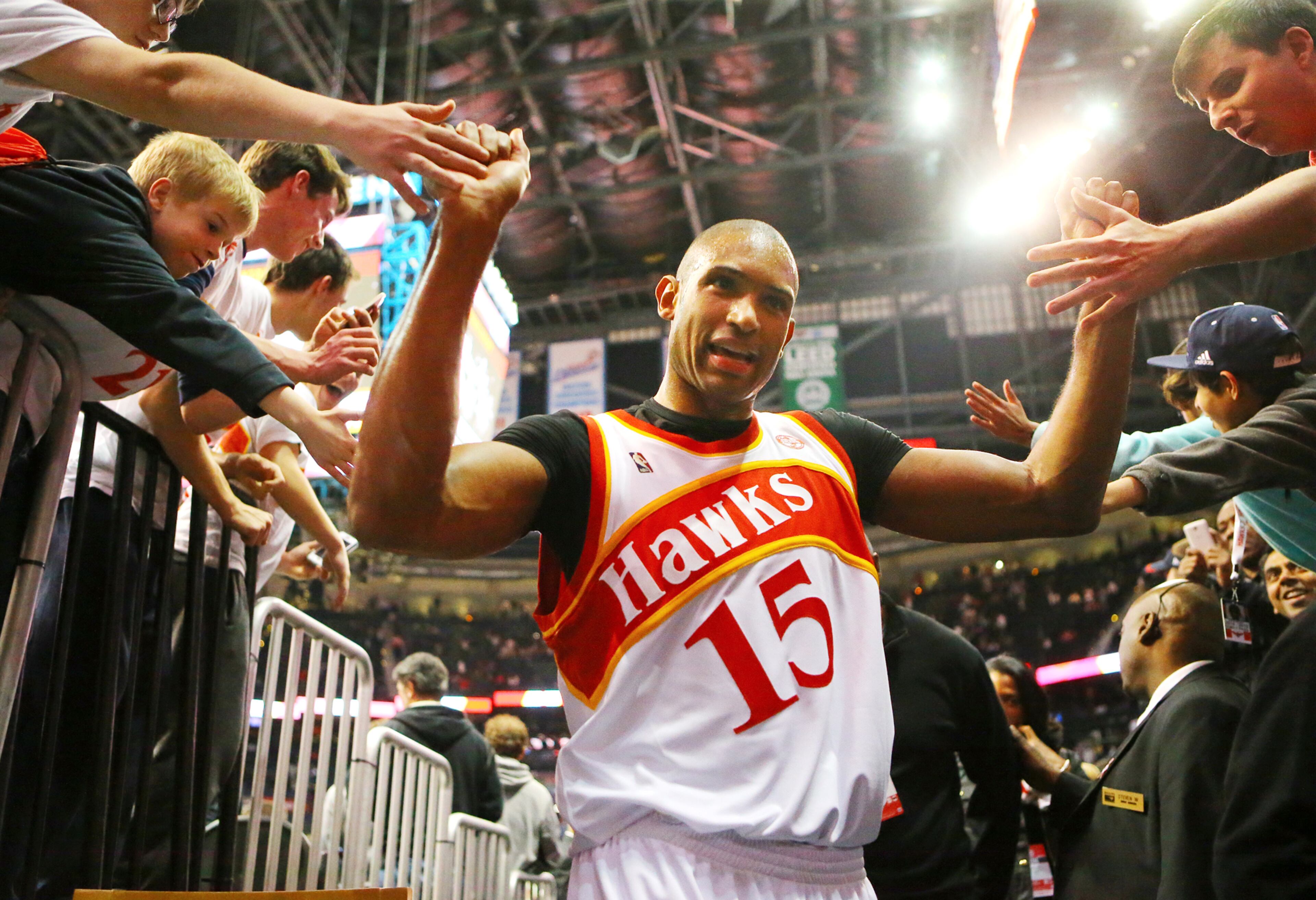 Hawks center Al Horford high fives fans while leaving the court on March 6, 2015. Curtis Compton / ccompton@ajc.com