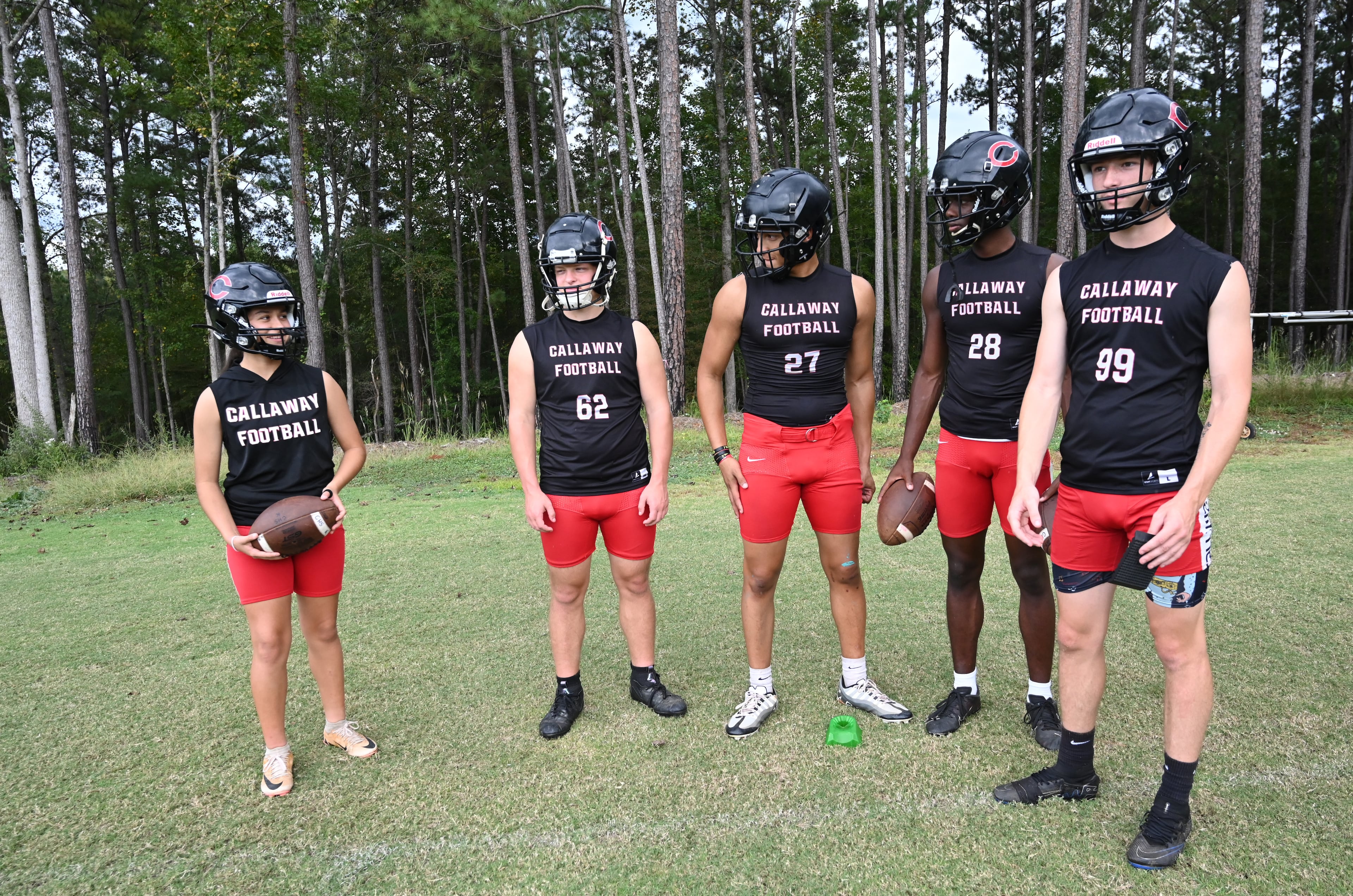 Callaway High’s Mia Flores (left) chats with teammates during football practice on Thursday, Sept. 25, 2025, in Hogansville. (Hyosub Shin/AJC)