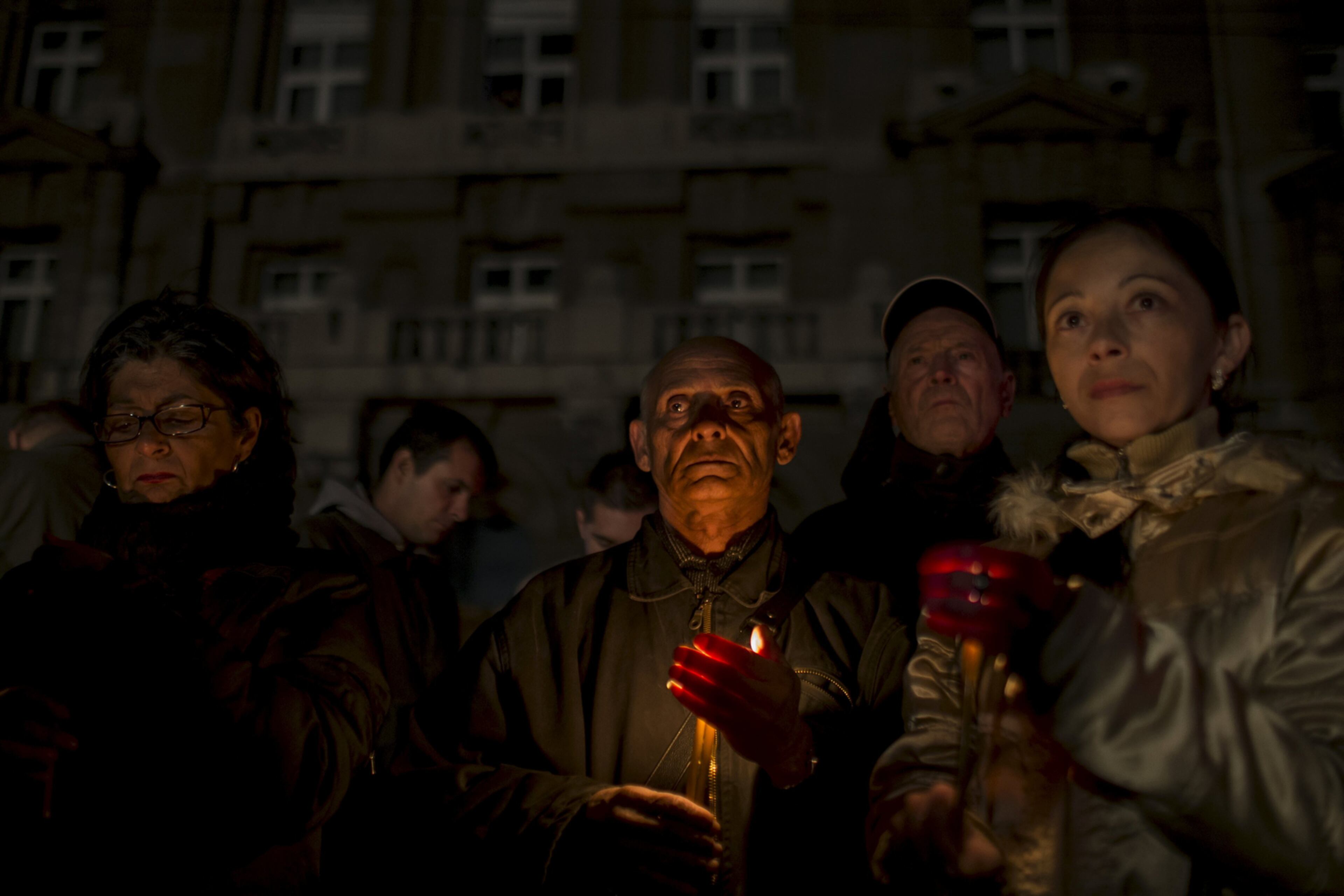 SERBIAN ANNIVERSARY--People hold candles during a minute of silence in front of a destroyed military headquaters as Serbia marks the 16th anniversary of the NATO bombing campaign in Belgrade March 24, 2015. Serbia on Tuesday marked the 16th anniversary of the beginning of NATO's air war against the country, then a part of the Federal Republic of Yugoslavia. REUTERS/Marko Djurica