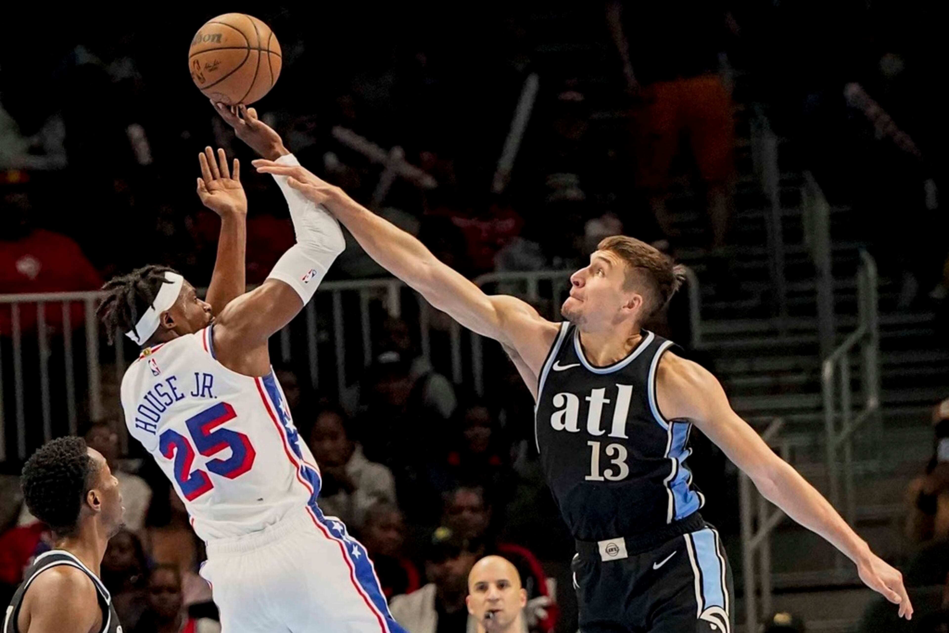 Philadelphia 76ers forward Danuel House Jr. (25) shoots against Atlanta Hawks guard Bogdan Bogdanovic (13) during the first half of an In-Season Tournament NBA basketball game, Friday, Nov. 17, 2023, in Atlanta. The Hawks lost 126-116. (AP Photo/Mike Stewart)