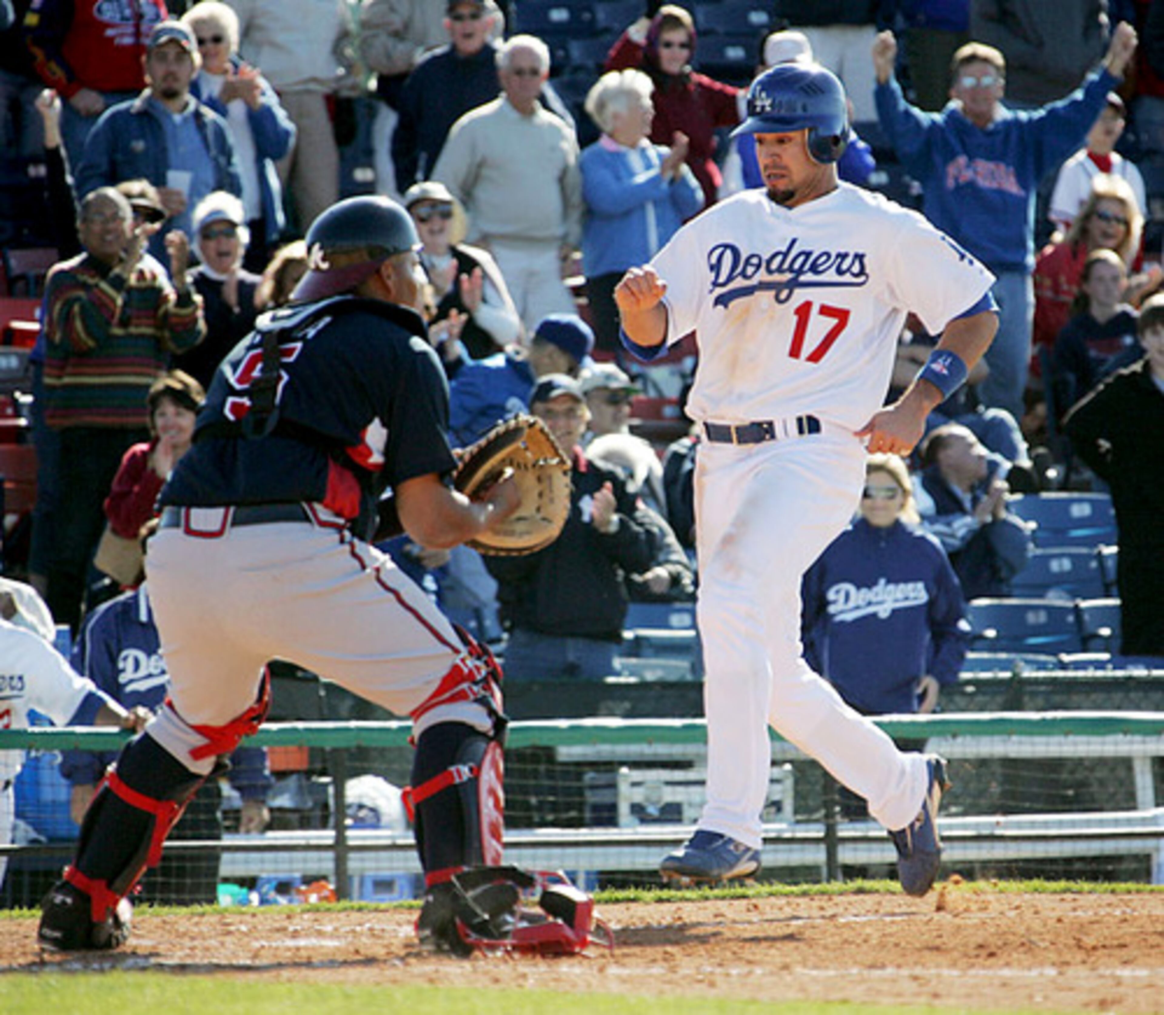 Braves catcher Brayan Pena waits for a throw to home as Dodgers outfielder Jason Repko scores the winning run against the Braves at Hollman Stadium in Vero Beach.