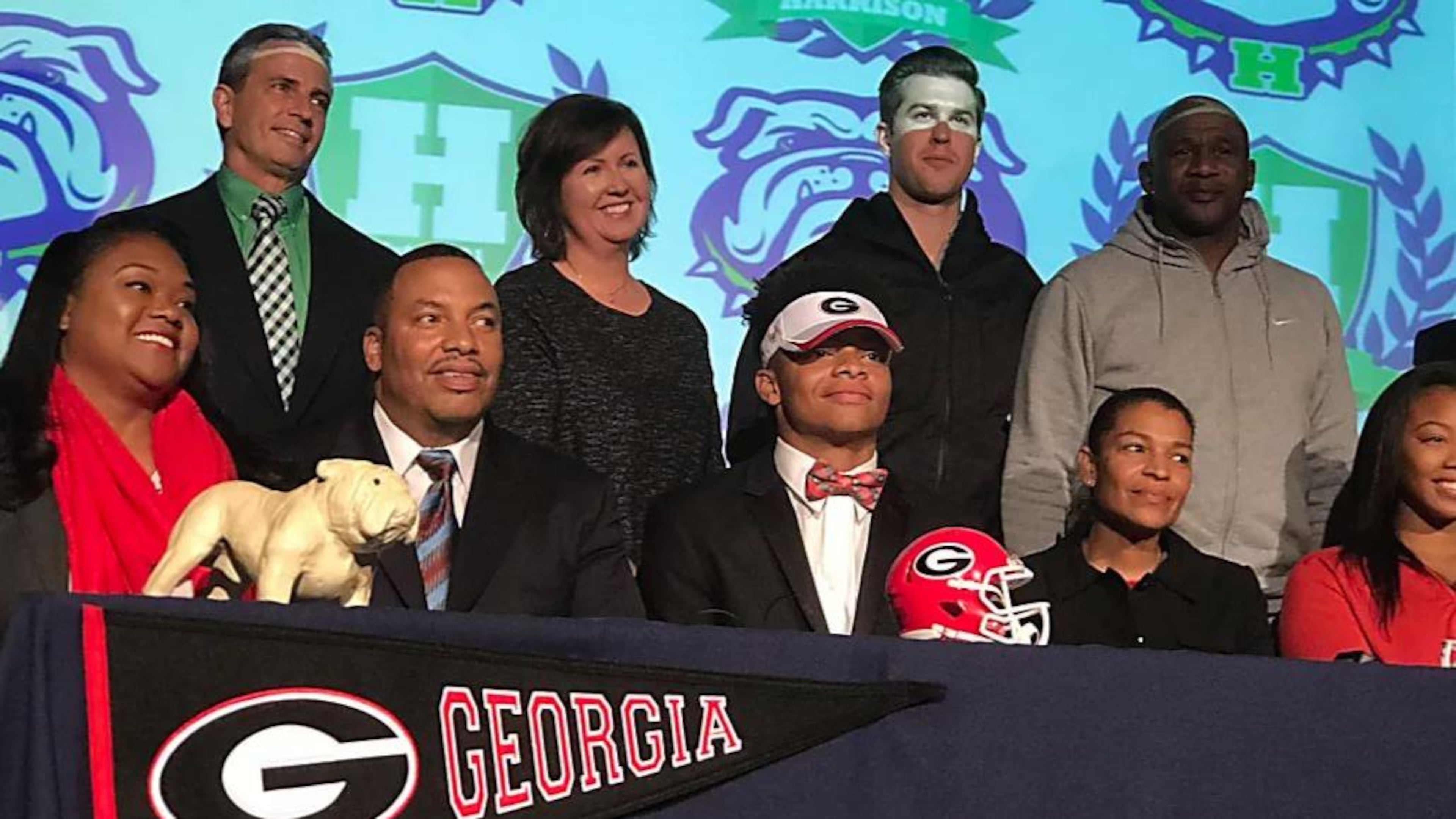 Surrounded by family and school officials, quarterback Justin Fields (center) signed his letter of intent with Georgia Wednesday at Harrison High School.