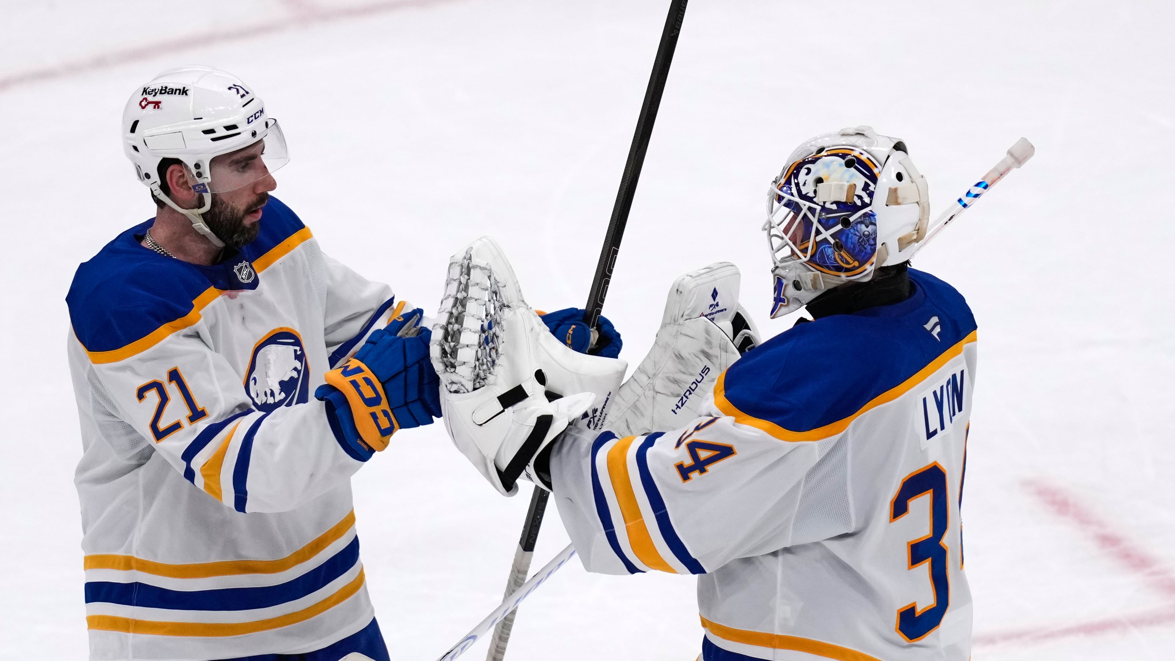 Buffalo Sabres goaltender Alex Lyon (34) is congratulated by Conor Timmins (21) after defeating the Boston Bruins in Game 3 of a first-round NHL hockey Stanley Cup playoff series, Thursday, April 23, 2026, in Boston. (AP Photo/Charles Krupa)