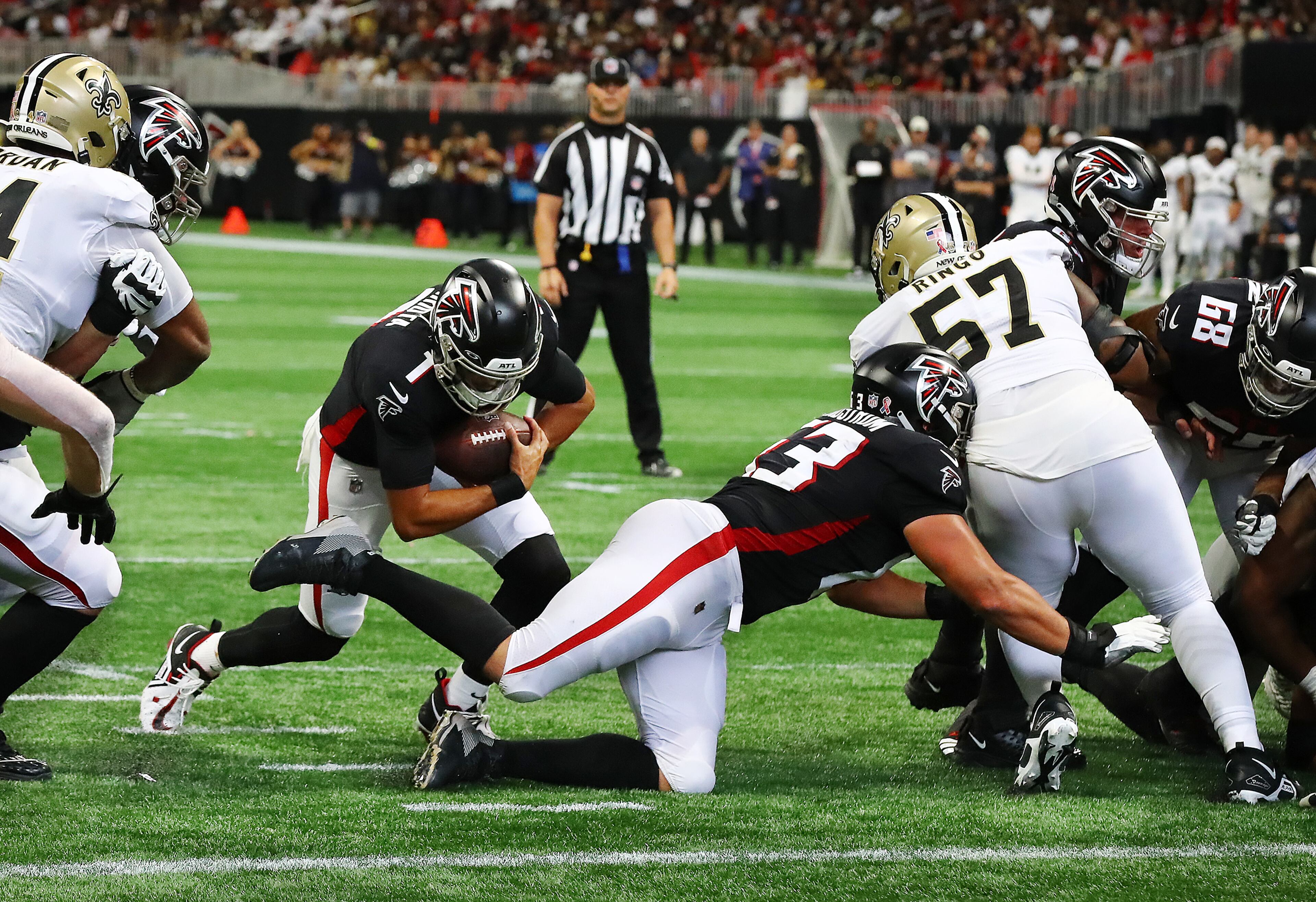 Falcons quarterback Marcus Mariota follows a block by guard Chris Lindstrom into the end zone during the third quarter Sunday. (Curtis Compton / Curtis Compton@ajc.com)