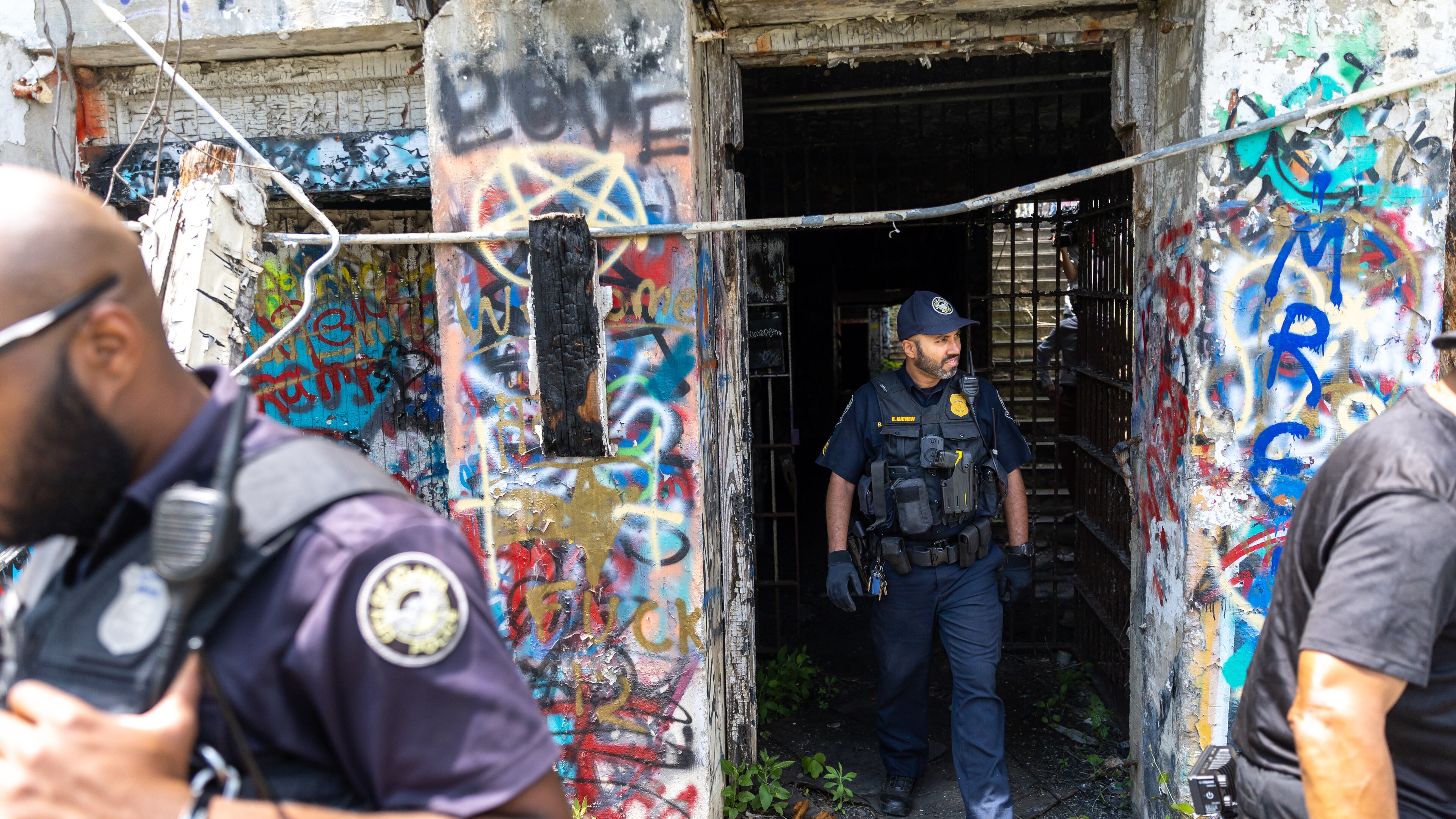 Officers walk out of an old prison farm building during an Atlanta Police Department and Atlanta Fire Rescue media tour of the Atlanta Public Safety Training Center site on Friday, May 26, 2023. (Arvin Temkar / arvin.temkar@ajc.com)