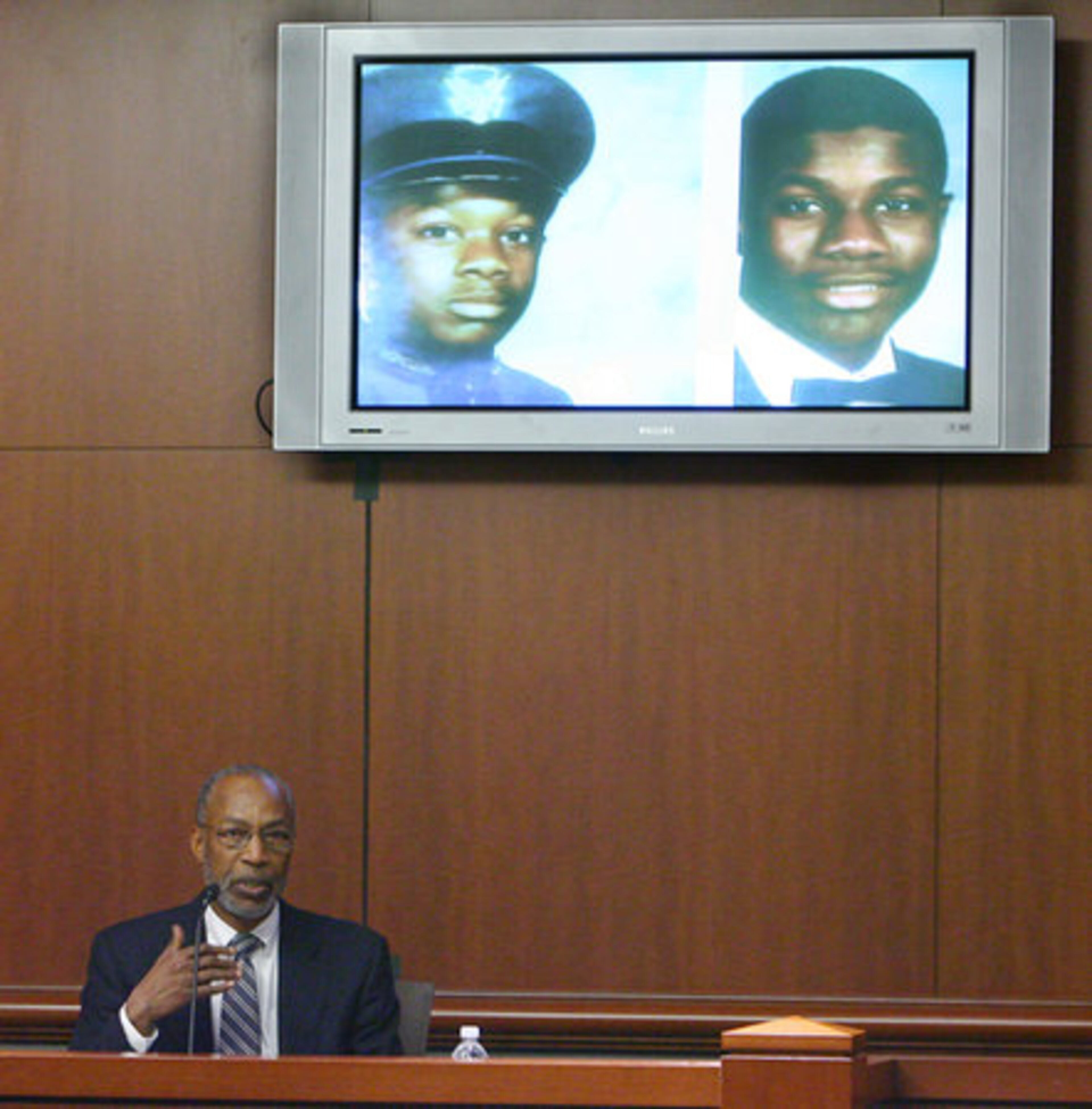 Dr. Richard G. Dudley Jr. testfies as the screen behind him shows schools photos of Brian Nichols in military school (left) and high school. Dudley testfied that Nichols was sexually abused as a child and neglected during much of his childhood.