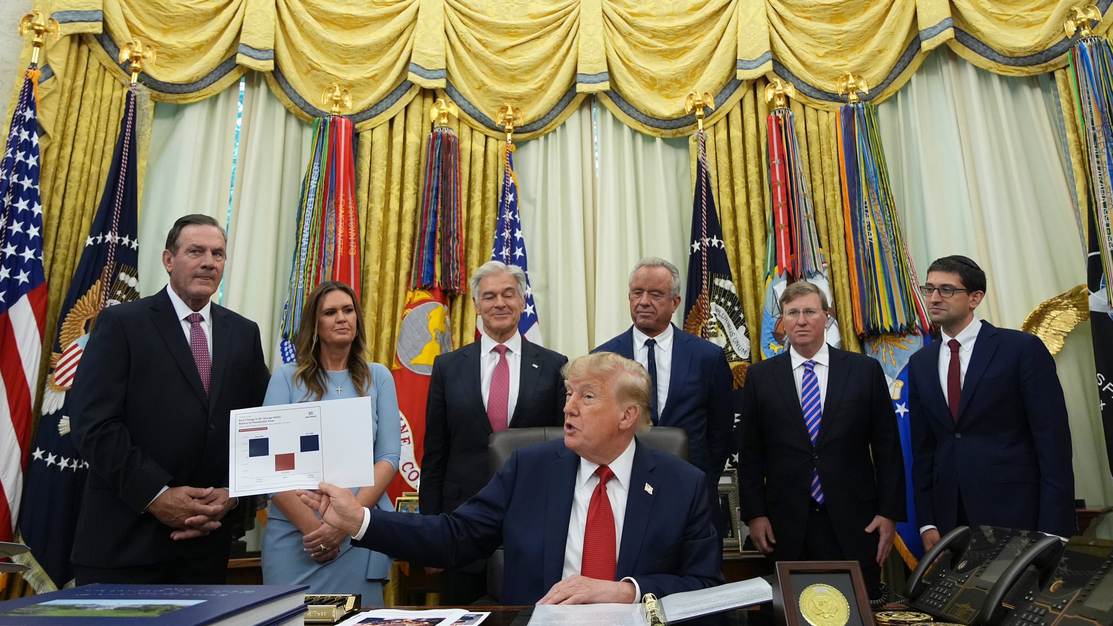 President Donald Trump speaks as South Dakota Gov. Larry Rhoden, from left, Arkansas Gov. Sarah Huckabee Sanders, Mehmet Oz, administrator of the Centers for Medicare & Medicaid Services, Health and Human Services Secretary Robert F. Kennedy Jr., Mississippi Gov. Tate Reeves and Abe Sutton, director of the Center for Medicare and Medicaid Innovation, listen during an event about healthcare in the Oval Office of the White House, Friday Sept. 18, 2026, in Washington. (AP Photo/Jacquelyn Martin)