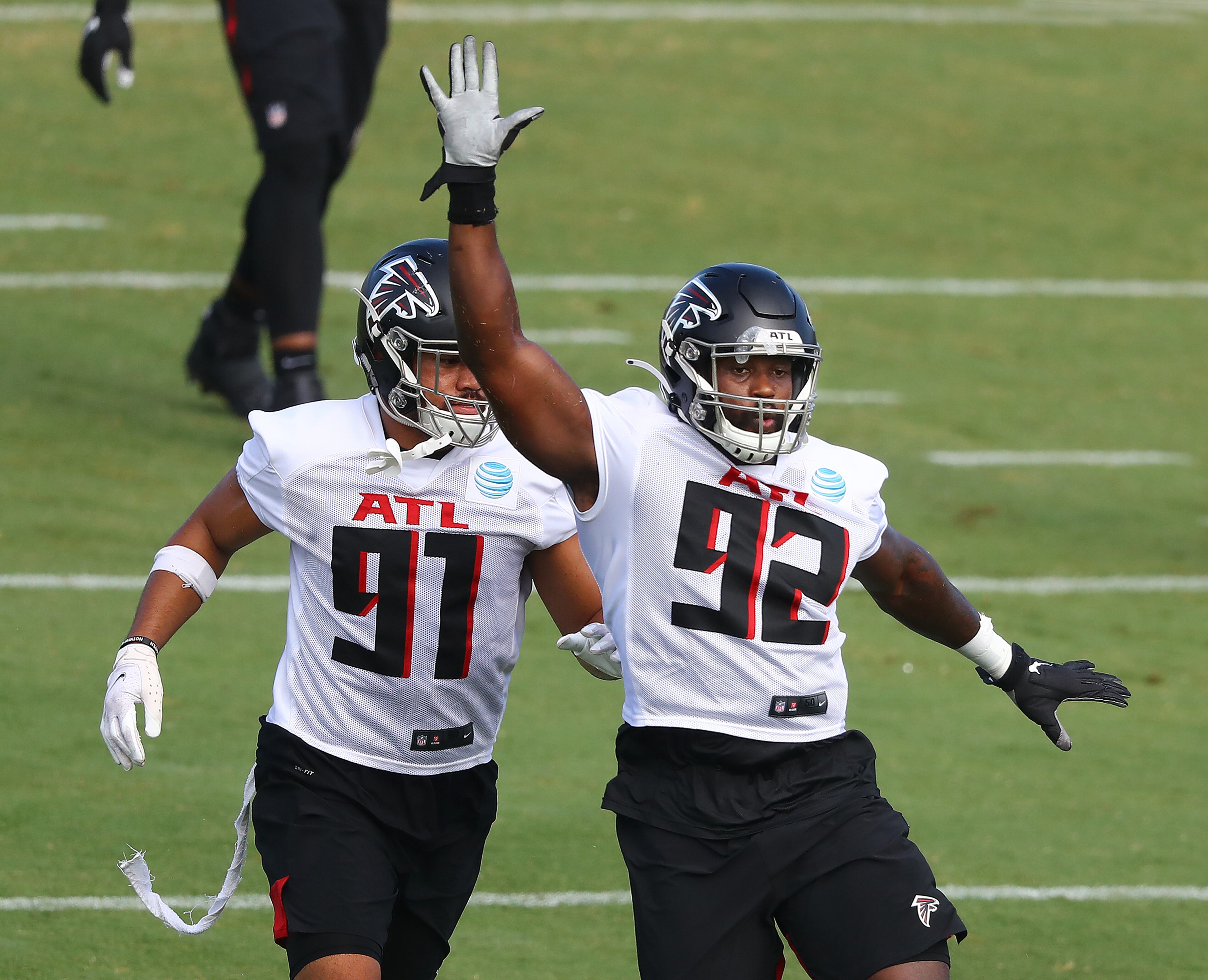 Falcons defensive tackle Jacob Tuioti-Mariner (left) and defensive end Charles Harris get in some pass rush work during practice Wednesday, Aug. 19, 2020, in Flowery Branch.