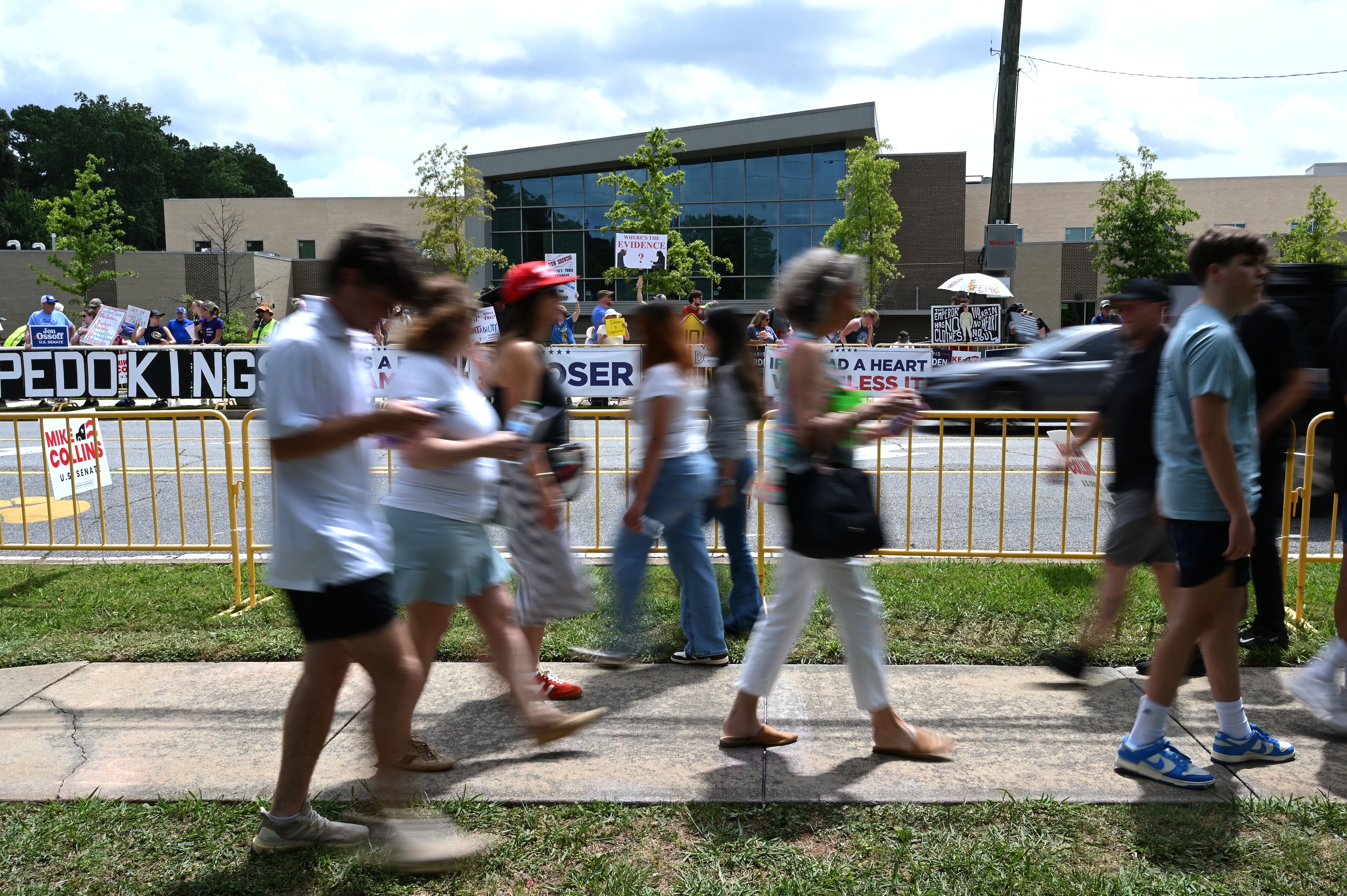People, background, protest as President Donald Trump supporters arrive outside Wheeler High School on Wednesday, July 22, 2026, in Marietta. President Donald Trump is visiting Cobb County’s Wheeler High School on Wednesday to promote a new investment account for children. (Hyosub Shin/AJC)