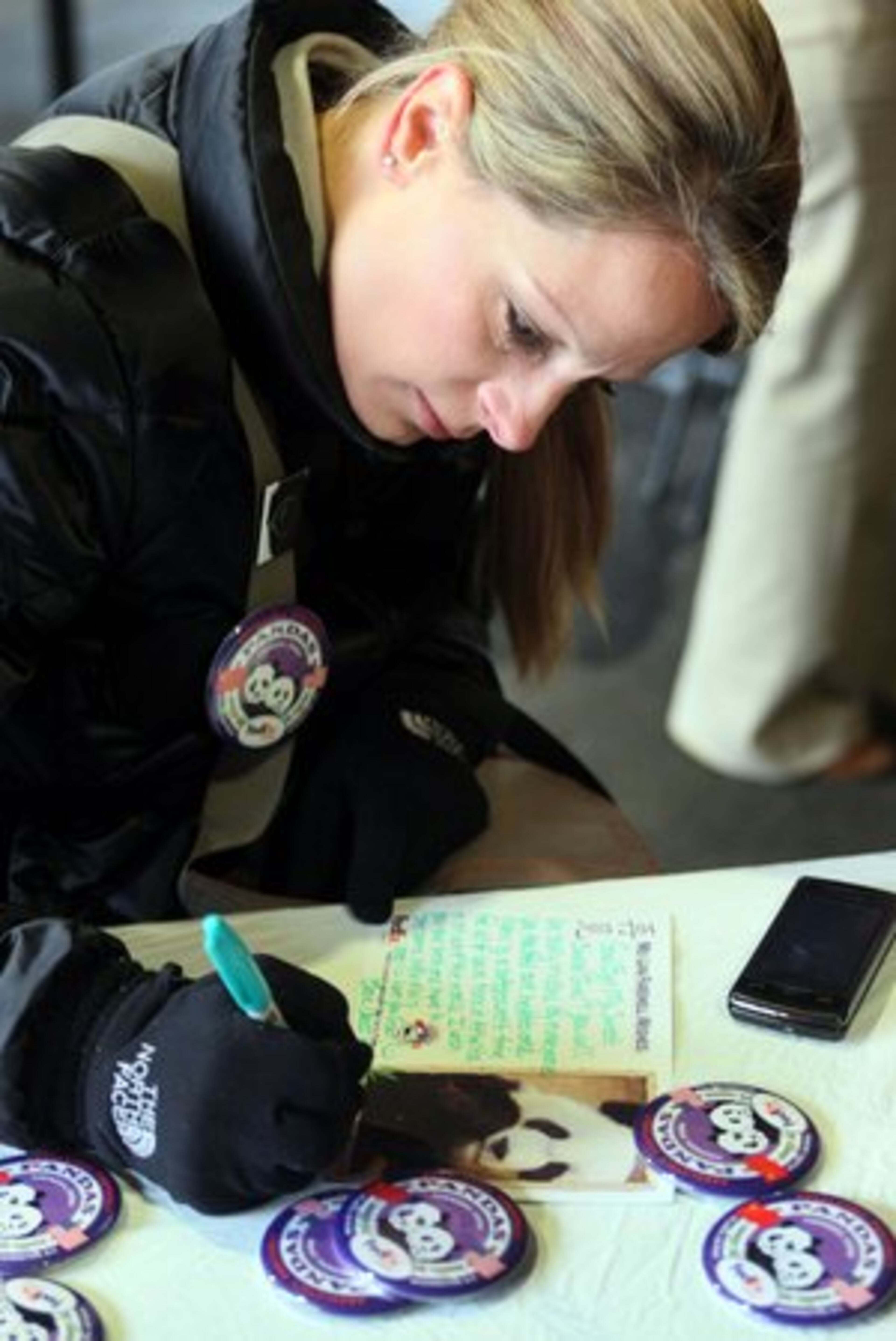 Erin Cross of Powder Springs writes a farewell card to Mei Lan during Saturday's event.