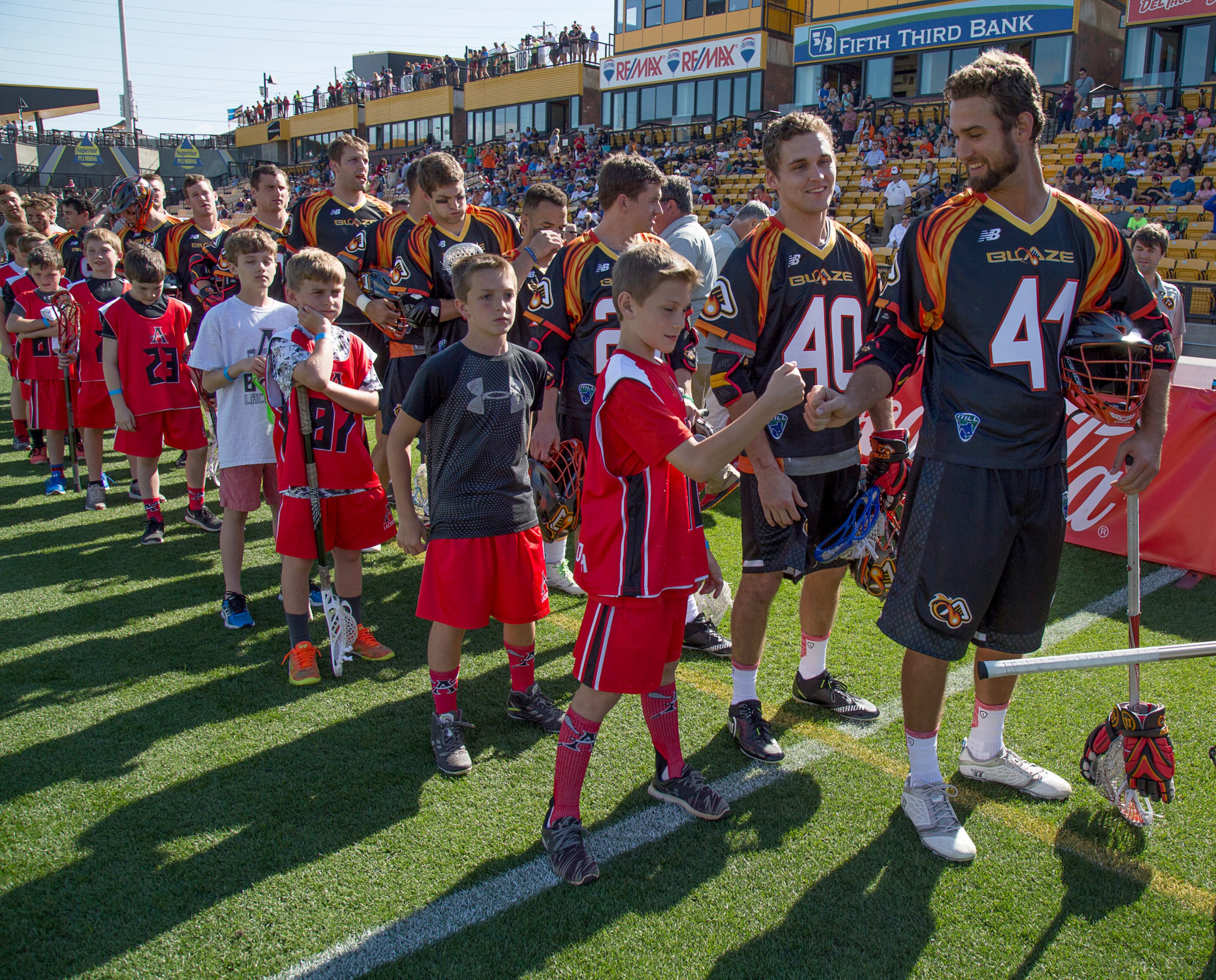 Kevin Cooper, (R) a midfielder for the Atlanta Blaze, metro's newest professional sports franchise, talks with one of the members of the Allatoona U-11 Lacrosse team before the start of their inaugural game Saturday night April 23, 2016 in Kennesaw, Ga. A crowd of 4,145 was in attendance including hundreds of area youth lacrosse players. STEVE SCHAEFER / SPECIAL TO THE AJC