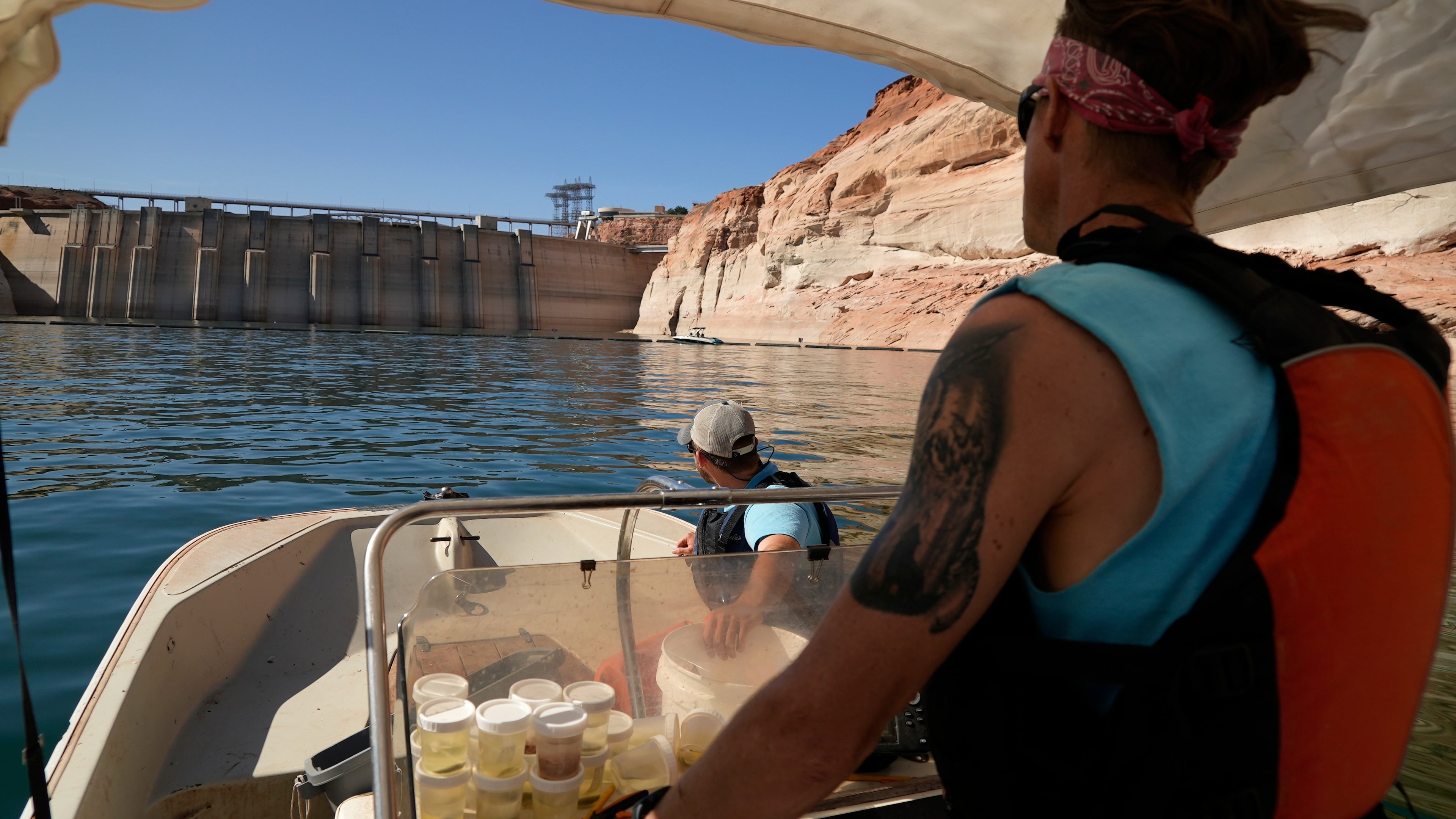 FILE - Utah State University master's student Barrett Friesen steers a boat near Glen Canyon dam on Lake Powell on June 7, 2022, in Page, Ariz. (AP Photo/Brittany Peterson, File)