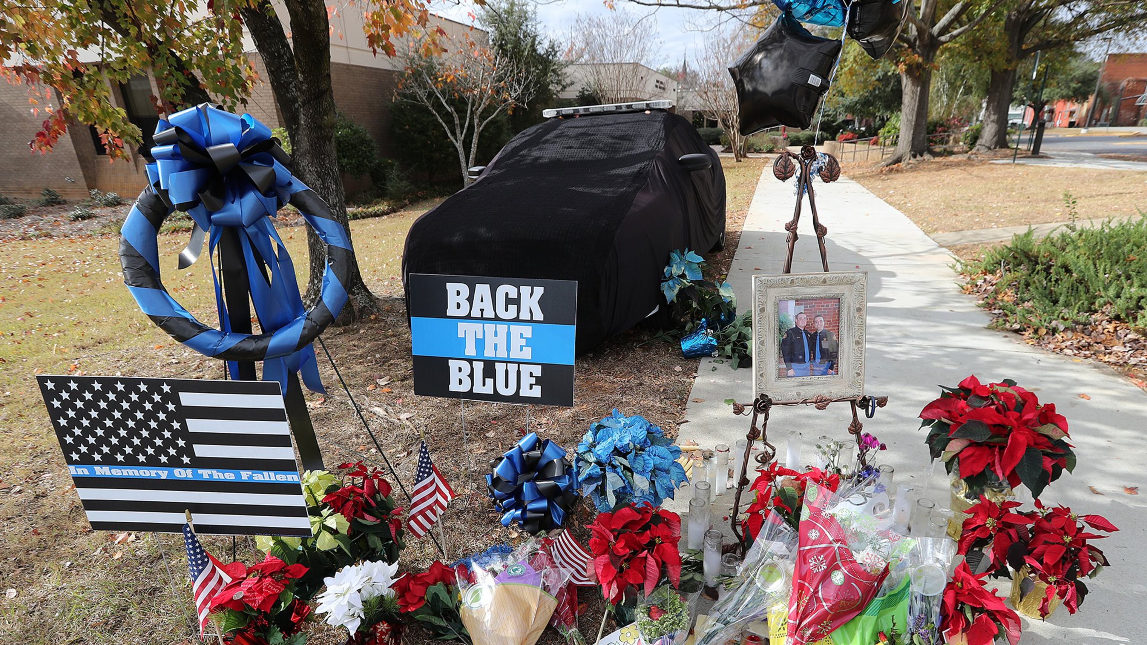 A memorial for Americus police officer Nicholas Ryan Smarr, his patrol car covered in black, sits outside the public safety building in Americus on Sunday, Dec. 11, 2016. His longtime friend and fellow officer, Jody Smith, is to be buried on Wednesday. (Photo: Curtis Compton/ccompton@ajc.com)