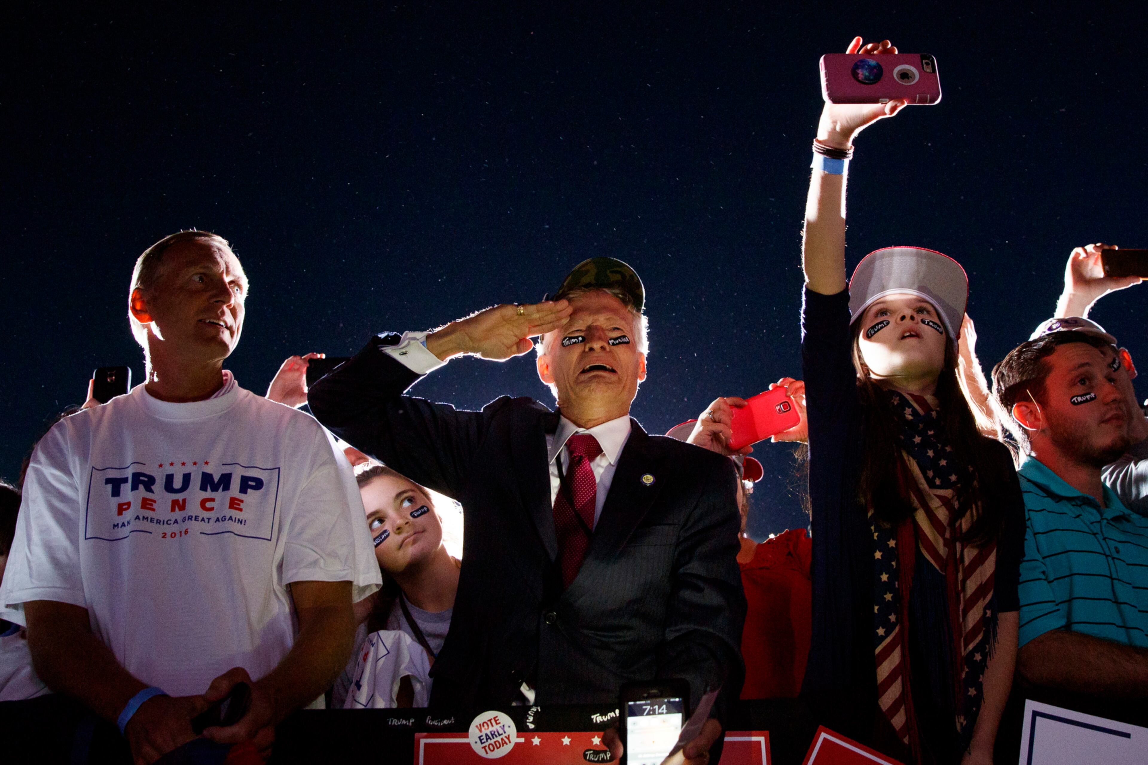 Jeff Muller of Wilmington, N.C., salutes as Republican presidential candidate Donald Trump arrives to a campaign rally, Wednesday, Oct. 26, 2016, in Kinston, N.C. (AP Photo/ Evan Vucci)