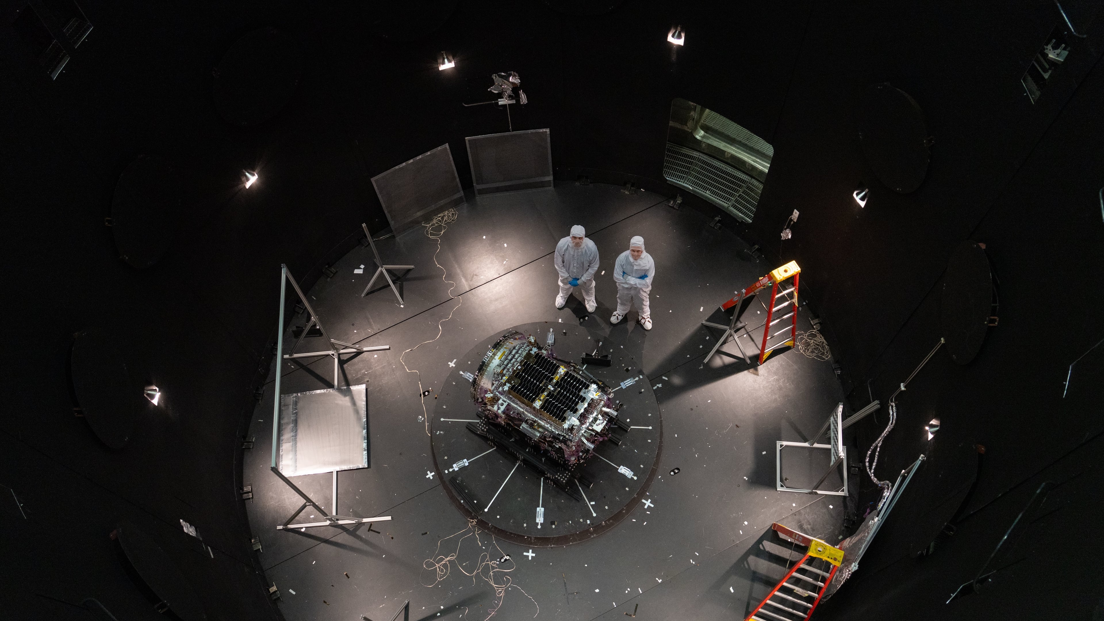 FILE - This photo provided by NASA shows Kieran Wilson, LINK's principal investigator, and Hunter Robertson, a space systems engineer, both at Katalyst Space, standing next to their spacecraft inside the SES (Space Environment Simulator) at NASA's Goddard Space Flight Center in Greenbelt, Md., April 17, 2026, ahead of thermal vacuum testing. (Sophia Roberts/NASA via AP, File)