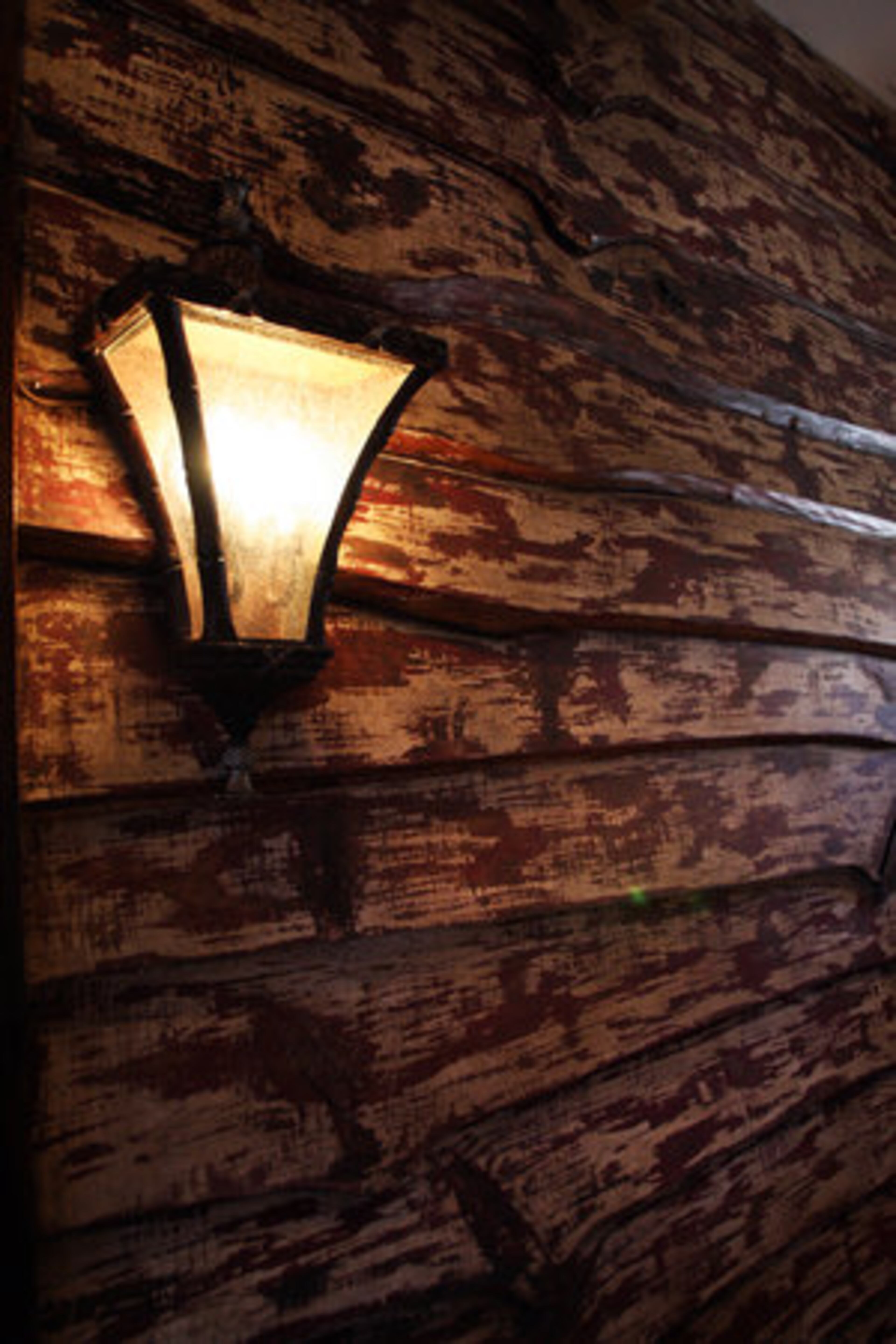 Joan Prater covered the outside wall of a guest room with old barn wood. It was originally black, but she had it painted to make it appear weathered. The Praters used drywall along with the logs in their home to give it a bright and cheery look.