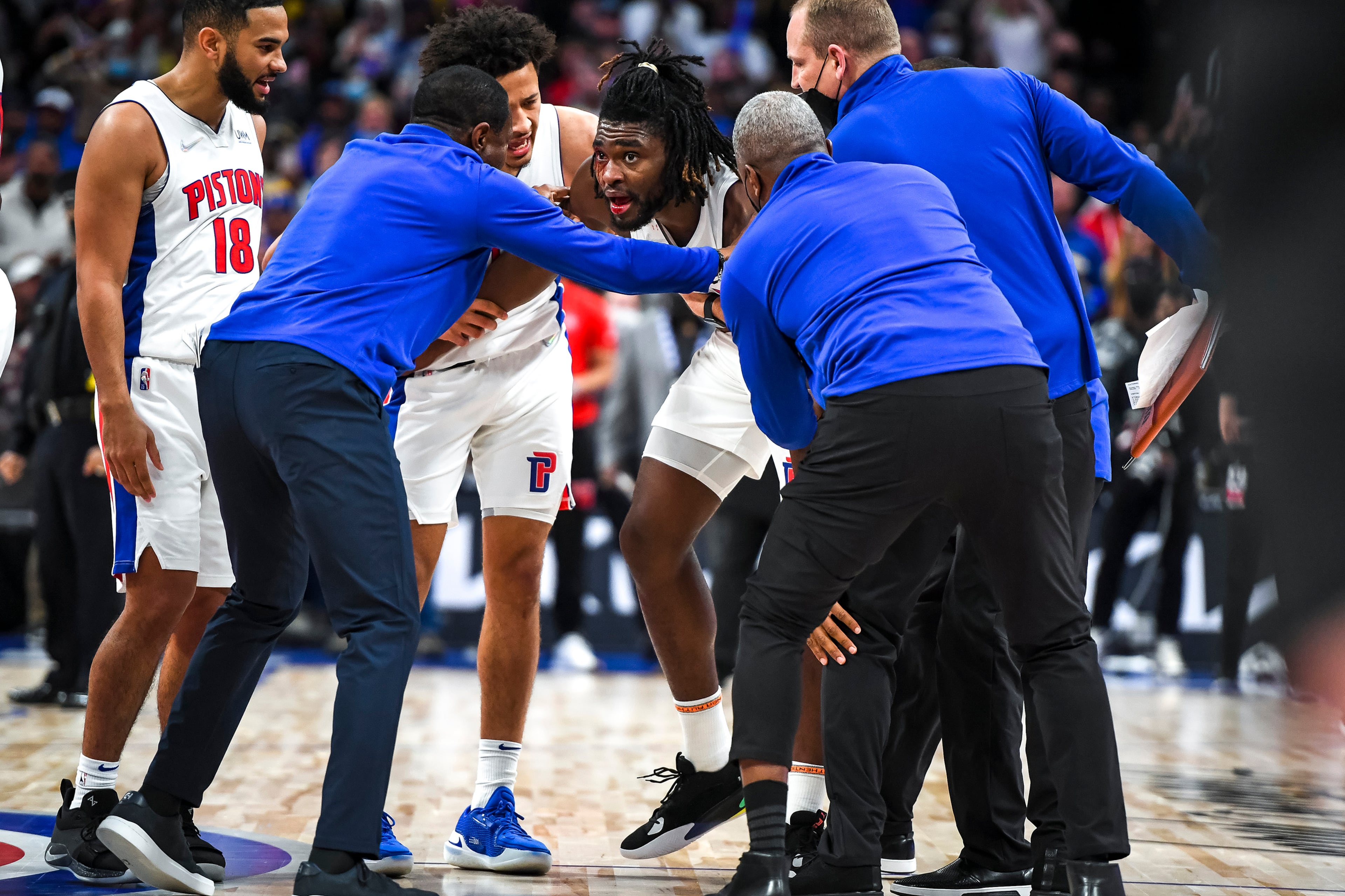 Isaiah Stewart (28) of the Detroit Pistons is restrained after receiving a blow to the face by LeBron James (6) of the Los Angeles Lakers during the third quarter at Little Caesars Arena on Sunday in Detroit.