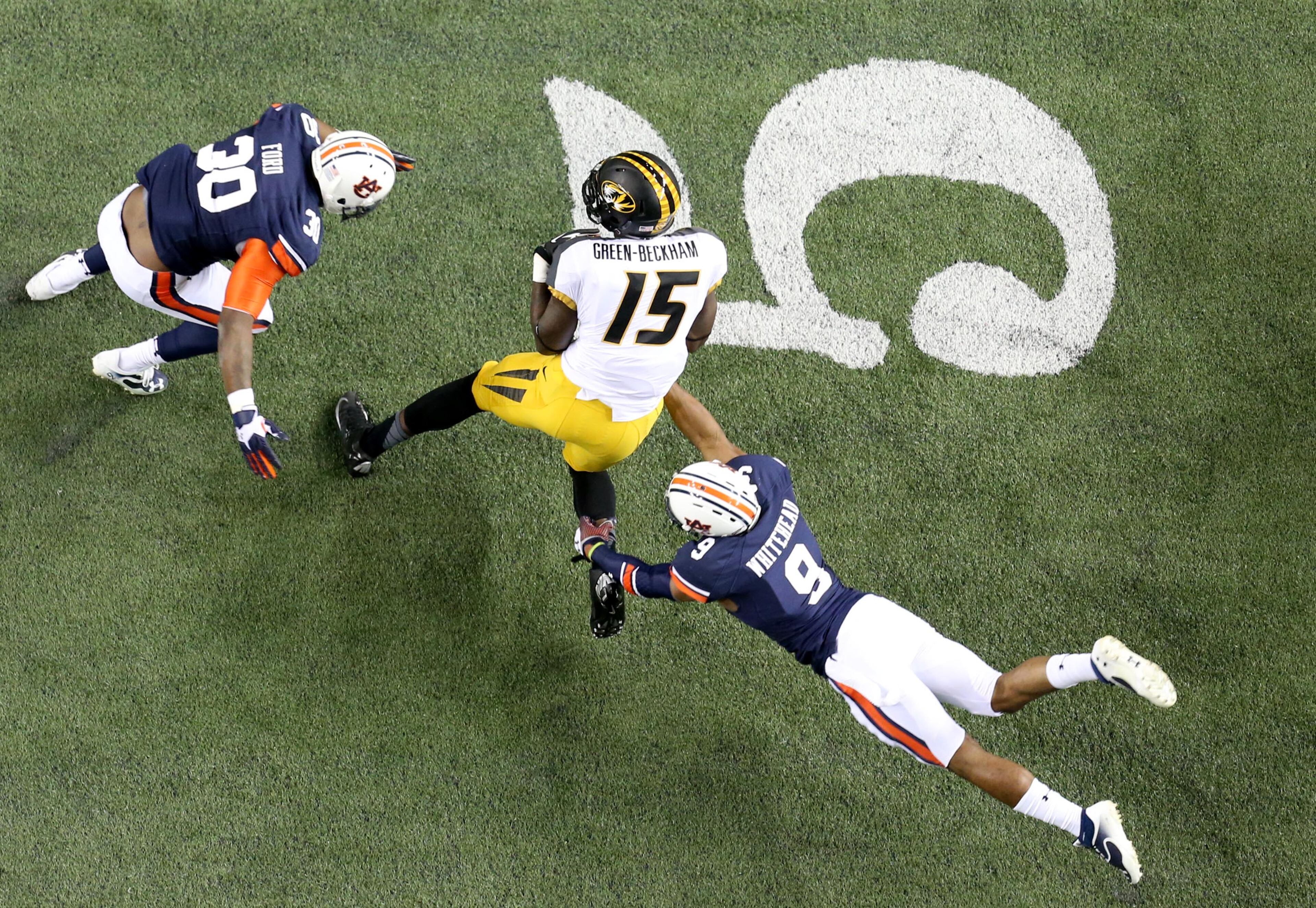 Auburn defensive back Jermaine Whitehead (9) makes a diving tackle attempt on Missouri wide receiver Dorial Green-Beckham (15) after Green-Beckham made a reception during Auburn's 59-42 win over Missouri in the SEC Championship Saturday night in Atlanta, Ga., December 7, 2013. Also shown on the play is Auburn defensive end Dee Ford (30). JASON GETZ / JGETZ@AJC.COM